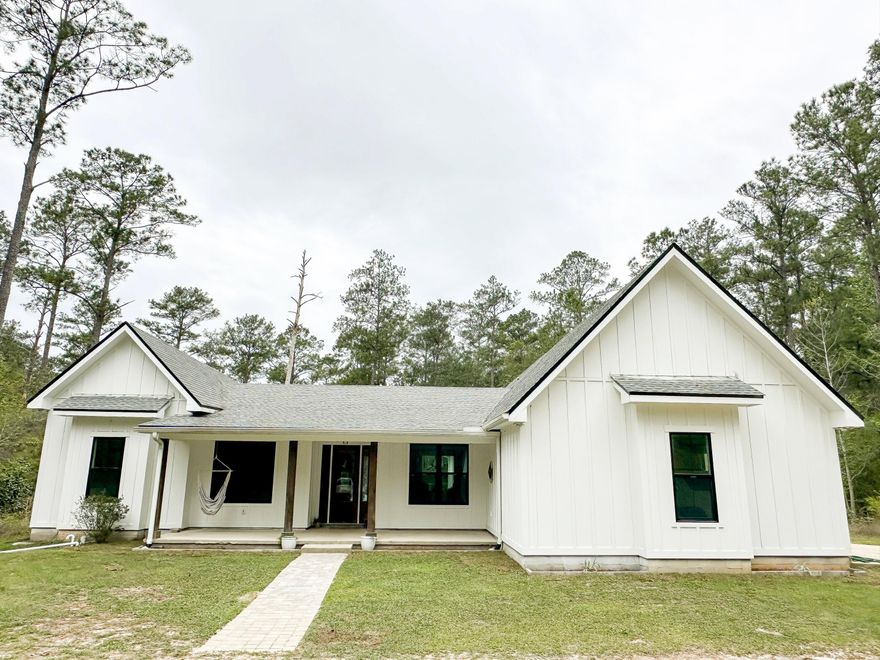 PEACEFUL, SECLUDED RETREAT. A must see! Rare opportunity to own 3.04 unrestricted acres outside the Freeport city limits. This custom farmhouse is ready for you to make it your home. Imagine waking up to a backyard full of songbirds on your own private estate. This custom-built farmhouse is a true homesteader's dream. A warm, welcoming space ready for you to fill with laughter, memories, and the simple joys of country living. The wooded driveway provides privacy on all sides and leads you to the farmhouse of your dreams. Step inside through the inviting entryway that flows seamlessly into an open-concept living room and kitchen, where natural light fills the space and every moment feels connected. Perfect for family gatherings, holiday cooking, or quiet evenings together. Custom built-in pantry cabinets keep everything beautifully organized, brand-new stainless steel appliances and the 36" gas range make cooking a joy, and the thoughtful layout invites everyone to linger long after dinner is done. Every room in this home boasts soaring 10 ft ceilings. For the creative or productive soul, the fully insulated studio/office space (currently set up as a recording studio) offers endless possibilities: a home office, art studio or workspace. Fresh interior and exterior paint gives everything a crisp, clean canvas for your personal touches. The spacious master suite boasts 12 ft ceilings and a private entrance to the back porch, where morning light pours in. Unwind in the luxurious master bath with its deep soaking tub and spa-like shower. His and hers walk-in closets offer plenty of room for everything you love. The thoughtfully designed layout features 3 generous guest bedrooms and 2 full baths, one of which has an exterior door. With this layout, a pool would be the perfect addition to the backyard. Outside, the large screened porch is pure magic; ideal for quiet early-morning coffee with the sunrise or watching summer sunsets paint the sky. Towards the middle of the property, a large chicken coop with fencing is ready for your farming dreams. The firepit is perfect for ending your evening surround by family. The back of the property is still wooded; a blank canvas for gardening, farm animals or whatever your heart envisions. Abundant wildlife and wild blueberry and blackberry bushes are also sprinkled throughout the property. You're only 8 minutes to Freeport for everyday conveniences, yet just 25 minutes from the sugar-white sands and emerald waters of 30A beaches. Head 45 minutes to vibrant Panama City or Destin for dining, shopping, and entertainment. All while returning each evening to your own tranquil slice of Florida. This is more than a house; it's the cozy, peaceful homestead you've been envisioning. A rare opportunity to own unrestricted land with room to garden, roam, or simply breathe. Come make it your home.