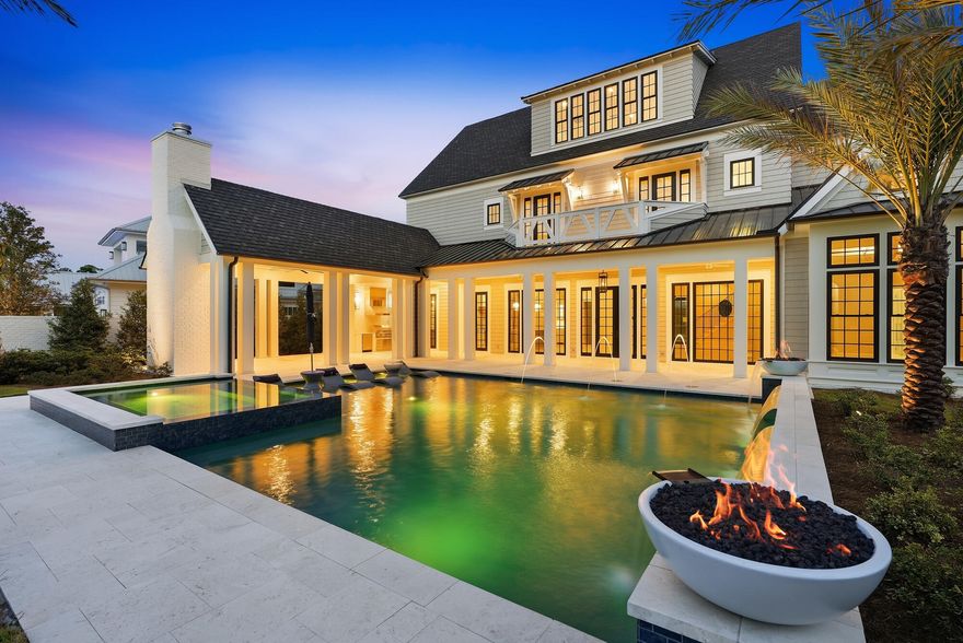 At 107 Quail Hollow Court in WaterSound Camp Creek, outdoor living takes center stage. Designed with entertaining in mind, the home's outdoor spaces extend seamlessly beyond the interior, opening to a backyard that feels both expansive and intentional. A heated saltwater pool with elegant fire bowls commands attention, offering a resort-caliber setting that invites you to slow down and stay awhile.
 The scale of the outdoor environment is what truly distinguishes this residence. The pool terrace gives way to a remarkably generous yard, creating a sense of openness rarely experienced in WaterSound Camp Creek. There is space to host, to play, to unwind, and to simply enjoy the luxury of having room to breathe. Whether it is a lively evening gathering or a quiet morning with coffee in hand, the setting adapts effortlessly to the rhythm of life.

A fully equipped outdoor kitchen and fireplace complete the experience, allowing days to transition naturally into evenings spent beneath the coastal sky, where every detail has been designed for comfort, connection, and elevated living. One of the defining advantages of Camp Creek living is the inclusion of a WaterSound Beach Club membership, offering access to Gulf-front amenities that further extend the lifestyle beyond the home.

Inside, the home continues to impress with a thoughtful balance of scale, comfort, and refined design. Spanning 7,474 square feet across three levels, the residence offers six bedrooms, seven full bathrooms, and three half baths, along with a three-car garage. Warm hardwood floors, coffered ceilings, and carefully considered proportions create interiors that feel expansive yet welcoming from the moment you enter.

At the heart of the home, the kitchen is designed to support both everyday living and elevated entertaining. Custom cabinetry, Sub-Zero appliances, a generous walk-in pantry, and a dedicated scullery allow the space to remain polished while accommodating gatherings of any size. Nearby, a curated wine cellar offers a refined setting for collection and display, while the adjoining living area, anchored by a fireplace and custom built-ins, provides a natural place to gather, unwind, and connect.

Upstairs, the home unfolds with spaces designed for both recreation and retreat. A dedicated game room or bunk room offers a lively setting for gathering, while the third-floor movie room with wet bar provides a more private environment for film nights, celebrations, or relaxed evenings at home.

Throughout the residence, each space has been designed with intention, balancing elegance with livability. With its generous scale, curated finishes, and exceptional indoor and outdoor living, 107 Quail Hollow Court presents a home where everyday moments feel elevated and the coastal lifestyle is experienced at its fullest.