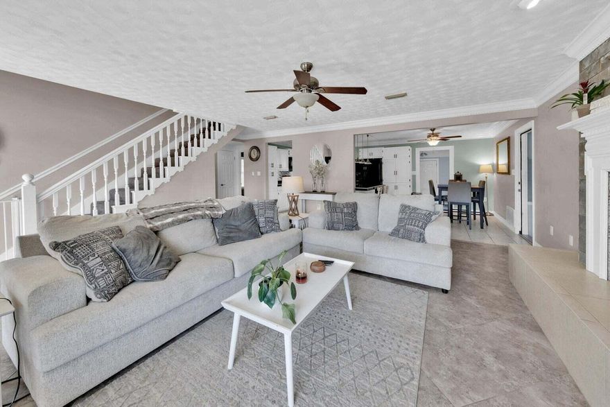 This two-story, 4-bedroom, 2-bath Cape Cod-style home offers generous space inside and out, conveniently located near military bases, shopping, and Navarre Beach. Inside this 1,750-square-foot home, you'll find great entertaining space in the large open-concept living room featuring tile flooring, a wood-burning fireplace, and a new shiplap accent wall. The kitchen showcases freshly painted cabinets with new hardware, a new tile backsplash, and a new dishwasher. Granite countertops and modern pendant lighting over the breakfast bar complete the look, and a spacious laundry and mudroom just off the kitchen leads to the backyard. Two well-sized downstairs bedrooms provide flexibility for guests, a home office, or playroom. Updated LVP flooring adds durability and modern style.