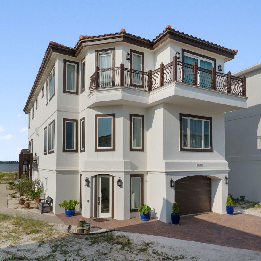 Exquisite Waterfront Residence in Sailmaker Cove. Step into a world of luxury and authenticity,  nestled within a prestigious gated community, the home offers unique character and essence.This custom-built residence  seamlessly blends timeless coastal design with elevated Mediterranean elegance. Forever views, surrounded by the serene landscape of Gulf Islands National Seashore. 
Upon arrival, the property makes an immediate impression with its elegant white stucco exterior and Spanish cement tile roof, complemented by a beautifully designed wrought iron balcony offering captivating views of the Gulf and it's pristine sugary beaches. Spanning over 3,794 square feet, this meticulously curated 4-bedroom, 5-bathroom home is designed to elevate your lifestyle and spirit. The first floor features an open-concept layout, perfect for gatherings, that effortlessly integrates into a chef's dream kitchen, adorned with high-end, custom solid wood cabinetry and stone countertops. Imagine dining while savoring breathtaking sunsets from the comfort of your home.
Additional highlights of the first floor include a spacious bedroom suite with a luxurious bath. Tiles and hard wood flooring and a host of subtle custom finishes thoughtfully designed throughout the home such as imported sinks, a stunning cement wall for showcasing your favorite wines, and exquisite 19th-century European stained glass above bedroom doors and throughout selected walls really showcase this spectacular home. The spacious primary suite on the second floor serves as a true retreat, boasting a cozy sitting area, custom built-ins, and a private balcony with breathtaking views of the Gulf. Two additional guest bedrooms, each with en-suite baths and picturesque views of the sound and national park, provide ample space for family or guests.The garage is equally impressive, with high ceilings and generous storage space, including an area designed for a golf cart.
The rear exterior of the home is perhaps its most enchanting feature, inviting you to relax or entertain at any time of day while being embraced by nature. Whether you prefer watching dolphins swim or enjoying a peaceful read, this unique setting promises to be a spectacular experience.Conveniently located just across from a tranquil, less-crowded beach. Take a short, scenic ride through the park to the vibrant Pensacola Beach for an array of dining and entertainment options. Sailmaker Cove provides a serene gated community experience, bordered by natural beauty, including the stunning Santa Rosa Sound.
Residents also have access to the refreshing community pool, making this property an ideal choice for a primary residence, vacation home, or a lucrative short-term rental opportunity. This home is truly a rare gem that will not disappoint!