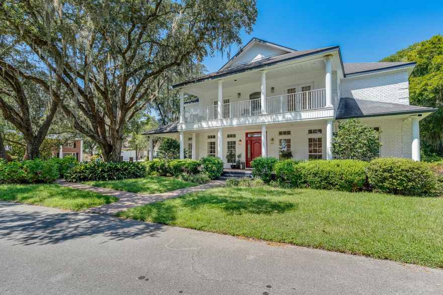 Timeless Elegance Meets Modern Comfort! Nestled on a generous corner lot spanning over 4,500 sqft, this stately 6-bedroom Colonial-style residence offers the perfect harmony of classic charm and contemporary luxury. A spacious 3-car garage welcomes you home, while inside, soaring vaulted ceilings and a grand marble fireplace set the tone for gracious living. The chef's kitchen is a true centerpiece—featuring sleek countertops, premium appliances, and a cozy breakfast nook ideal for morning coffee or lively gatherings. Multiple wrap-around porches invite you to unwind with panoramic views of lush, manicured landscaping—whether you're dining alfresco, lounging with a book, or hosting under the stars. Step through the expansive lanai to discover a private screened-in pool and spa, seamlessly blending indoor and outdoor living. With doors that open wide to create a breezy, resort-style flow, this home is designed for year-round enjoyment and effortless entertainment.