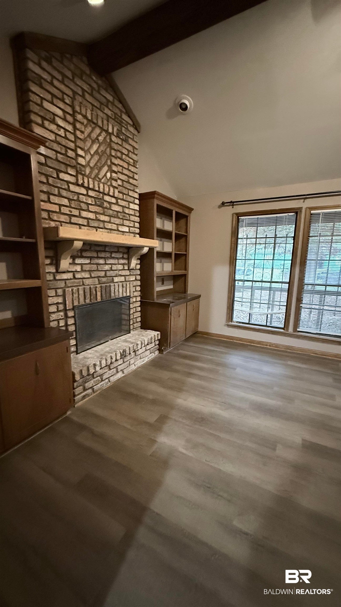 Unfurnished living room with a brick fireplace, dark wood-style floors, and recessed lighting