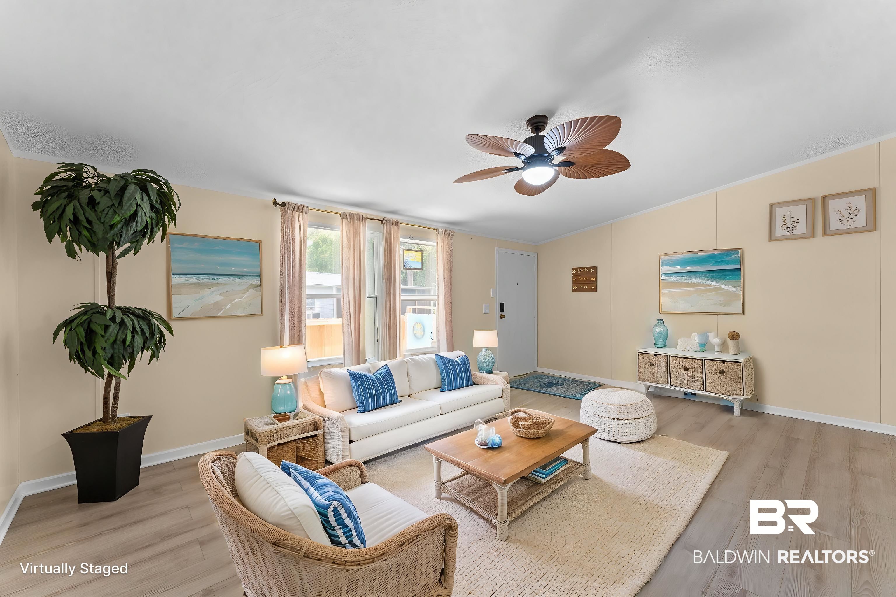Spacious living area featuring light wood-finish flooring, a contemporary ceiling fan, multiple windows for natural light, and neutral wall tones