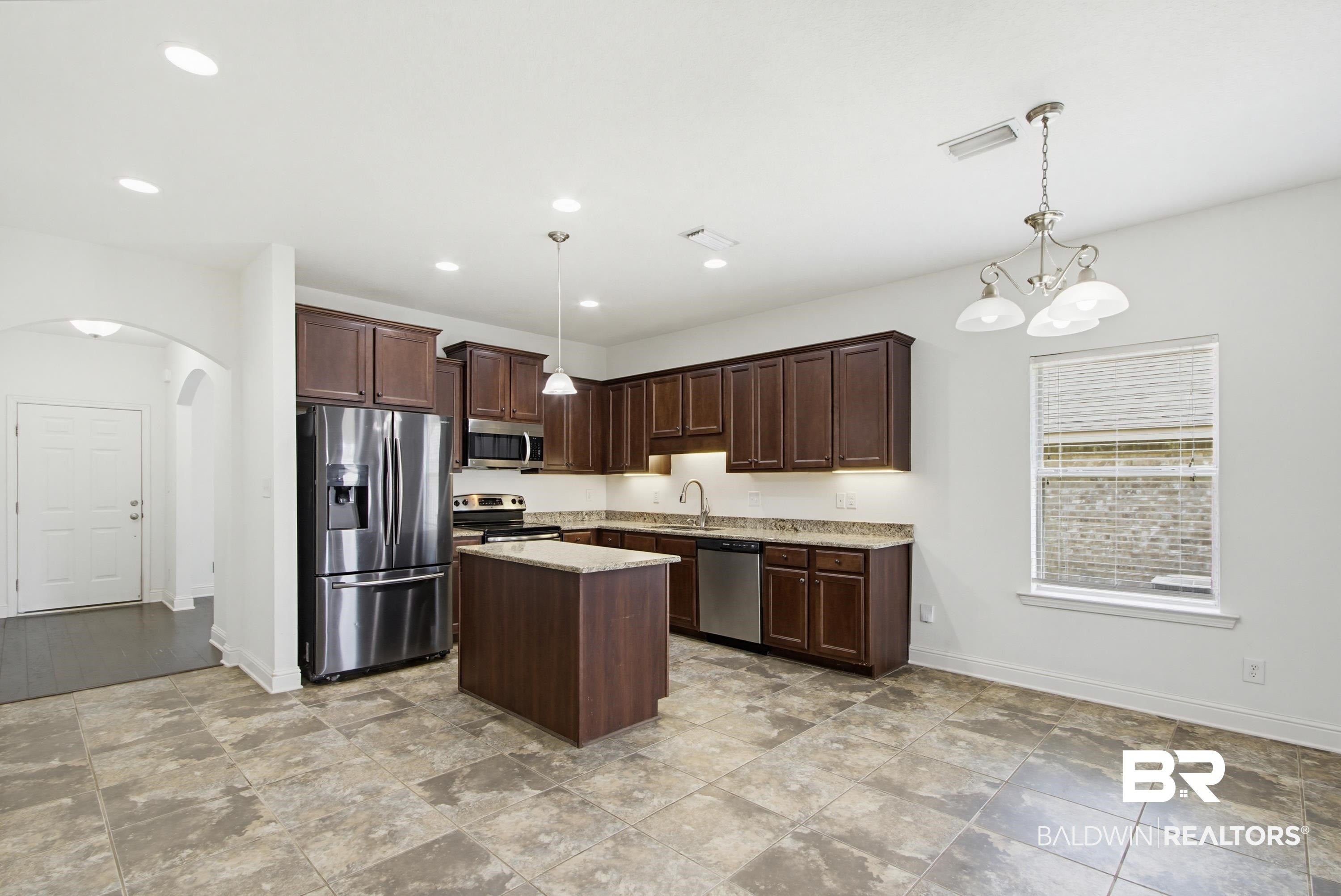 Kitchen featuring a central island, dark wood cabinetry, and stainless steel appliances