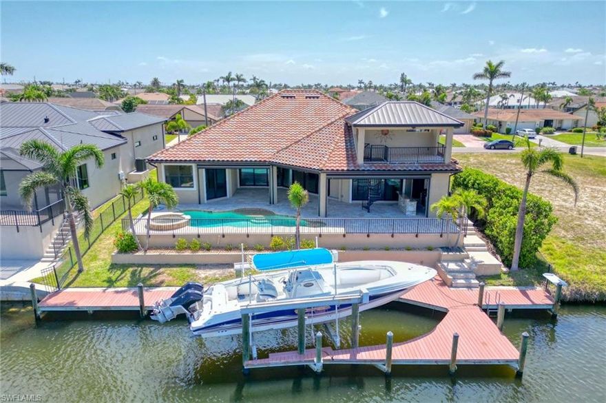 Welcome to your dream home! This stunning FOUR-bedroom, FOUR FULL bath Mediterranean style home, built by Tudor Villas in 2014, is perfectly situated on a direct-access canal with no bridges, in the highly sought-after SW Cape Coral area. Offering an exceptional blend of luxury and comfort, the "Ryker" model is perfect for entertaining. Enjoy the peace of mind provided by two high-efficiency AC units, electric roll-down screens, and hurricane shutters, alongside impact-resistant windows and doors throughout the home. Inside, you'll find tile and LVL flooring throughout, complemented by soaring high ceilings that enhance the airy, spacious feel. The attic is fully equipped with plywood flooring, offering plenty of storage space. For added convenience, gas connections are available for two future uses on the lanai (no tank onsite). A walk-in pantry, a generously sized laundry room, multiple walk in closets, and a saltwater pool with a heater and hot tub make daily living a breeze. This has been a one owner, smoke free home. Step outside into your private waterfront paradise, featuring a captain's walk with a boat lift, along with a fish cleaning station complete with water and electricity at the dock. Enjoy breathtaking views and fireworks displays from your 2nd story observation deck on special occasions, making every moment unforgettable. Conveniently located near restaurants, shopping, grocery stores, and schools, this home is just waiting for its new owners. Don't miss out on this incredible opportunity to make it yours—schedule your showing today! Please note that the boat in the back of home does not convey
