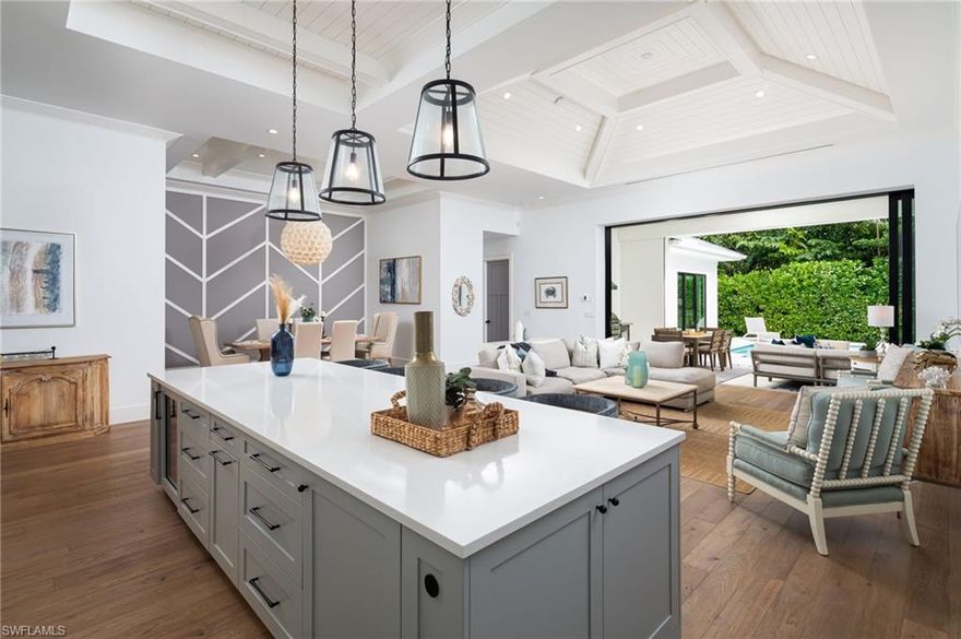 Thoughtfully designed by renowned architect Falconer Jones, this newer construction Lake Park home is just minutes to downtown Naples, with walkability to 5th Avenue and the beaches, offering modern coastal living with high-end finishes and seamless indoor-outdoor flow. The floor plan is ideal for entertaining and family gatherings, with wide-plank wood flooring throughout, designer tile, and curated finishes that give the home a clean, modern feel, while vaulted ceilings create volume and natural light across the main living spaces. The chef’s kitchen features custom KBC cabinetry, a large center island with pendant lighting, 36” gas cooktop, Samsung and Dacor appliances, and a wine cooler—designed for both everyday living and entertaining. The outdoor living space is a true highlight, featuring a south-facing gas-heated pool that enjoys sun all day, along with a water feature, covered lanai with roll-down screens, outdoor kitchen with gas grill, and outdoor shower—creating a private resort-style setting. Built with concrete block construction, PGT impact windows, and a standing seam metal roof for durability and peace of mind, along with an air-conditioned garage offering flexible use and added comfort. Located in the highly sought-after Lake Park neighborhood, just minutes to downtown Naples and 5th Avenue, in the heart of Olde Naples.