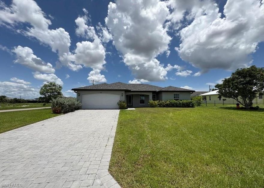Almost-new 3-bedroom, 2-bathroom home - CITY WATER AND SEWER -  located on a desirable corner lot in Southwest Cape Coral. This modern residence features an open floor plan with bright living and dining areas, tiled floors in the common areas, and carpeted bedrooms.  Island Kitchen, granite countertops, and stainless steel appliances. The master suite includes a walk-in closet and double sinks. Covered lanai provides additional outdoor living space. The driveway is finished with pavers. Laundry area is conveniently located inside the home. City water and sewer. Excellent location near Chiquita Boulevard and Pine Island Road, close to shopping centers, schools, and convenience stores. Rent this home as soon as possible—it won’t last long on the market!