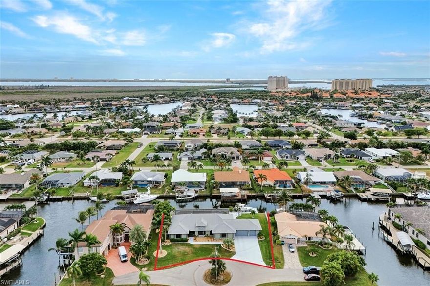 Boater’s Paradise! Welcome to this DIRECT GULF ACCESS pool home in the Tarpon Point area of SW Cape Coral. Completely reimagined and virtually BRAND NEW, this 3,100 SF home checks every box with 4 bedrooms, 3 full bathrooms, and large 3-car garage. Situated on an oversized triple .38-acre lot with 150 feet of waterfrontage, nearly 2x normal homes, this property accommodates multiple large boats while preserving unobstructed water views from the home and pool area! Enjoy SOUTHERN EXPOSURE for the most daytime sunlight on your pool & patio. Step inside to a modern, open-concept design with soaring cathedral ceilings, new wood-look flooring, and stunning panoramic water views. The designer kitchen is built for entertaining, featuring white Shaker cabinetry with illuminated upper cabinets, stainless steel appliances, a drawer microwave, and an oversized island with seating for 4 or more. A custom bar area with matching cabinetry creates a perfect flow for gatherings, entertaining, and family living. The Master Suite overlooks the water through a beautiful bay window and features tray ceilings, natural light, and generous closet space. The completely remodeled spa-inspired bathroom showcases marble, a custom walk-in shower, a designer tub, and dual vanities with illuminated mirrors. With 4 bedrooms, you have the flexibility to create a home office, a fitness room, or an in-law suite. Outdoor living with two waterfront areas - Enjoy a covered outdoor living room for lounging, and a separate dining area for entertaining. The oversized pool features a sun shelf, a deep swimming area, an outdoor shower, and a dedicated pool bathroom. A new panoramic picture window screen enclosure delivers breathtaking water views. The huge backyard is perfect for pets, children, and outdoor enjoyment. For boaters, this is unrestricted sailboat access, no bridges, no locks, and no delays. A new 10,000-pound remote-controlled lift is ready for your vessel, providing direct access to open water, Sanibel, Captiva, Pine Island Sound, and the Gulf. Built like a fortress! The home remained dry during hurricanes and features impact-resistant windows & doors, electric shutters on the patio, a metal roof, and extensive structural and mechanical upgrades. Renovations include removing walls to open the layout, new interior & exterior paint, new lighting, new fixtures, LVP flooring, two new AC systems, new hurricane windows & doors, a new water heater, a new pool heater & pump, updated plumbing & electrical, and a new remote boat lift motor. Experience the lifestyle of one of Cape Coral’s most desirable waterfront locations without HOA dues. Minutes from the new Bimini Square, The Cove, Slipaway, Tarpon Point Marina, and The Westin Cape Coral Resort, you are surrounded by some of the best waterfront dining & entertainment options in Southwest Florida. Nearby favorites include Gather, High Tide Social House, Pinchers, The Nauti Mermaid Bar & Grill, and Marker 92 Waterfront Restaurant.