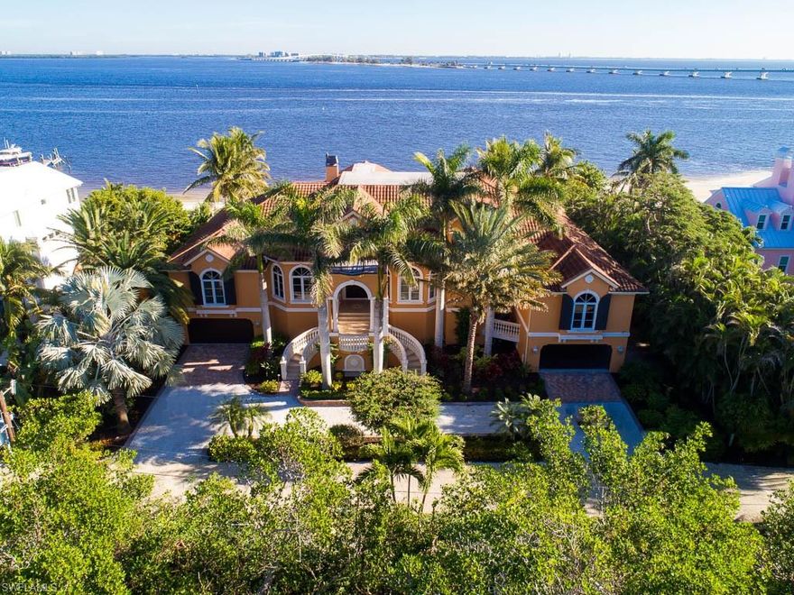 A breathless bay view sets the tone for this elegant and spacious 4 bedroom, 6 bath residence. With over 6,000 sq. feet, this epic bay front home welcomes you with a grand staircase into a domed foyer with inlaid marble floor and adjacent opulent dining, study, and three bed and bath guest wing. The voluminous living room prides a coffered ceiling, imported stone gas fireplace, and overlooks the waterfall pool and the bay beyond.  Impressive gourmet kitchen with professional appliances, custom marble sinks, cork flooring, and adjoining family room which boasts sliders onto lanai with outdoor kitchen, fireplace and fabulous view, is an entertainer’s dream. French doors lead to a magnificent master suite with morning kitchen, sitting area, and spectacular bath. Home theater with 100’ screen, stadium seating for 9, wet bar, bath, and lanai comprise the third floor. Designed like a resort, the heated pool with spillover spa and waterfall sits off 125’ of beach with bay access for water toys.
