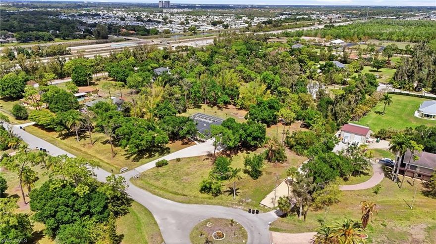 This exceptional property offers a rare opportunity to own a spacious, classic Florida home tucked away on a generous, private parcel of over two acres, giving you plenty of room to enjoy outdoor living and future expansion. Inside you’ll find a thoughtfully designed floor plan spanning approximately 2,275 square feet featuring a comfortable living space with three well-proportioned bedrooms and two full bathrooms, perfect for accommodating everyday life and personal retreat space. The heart of the home offers a welcoming living room anchored by a fireplace that invites cozy evenings and laid-back gatherings, while the kitchen is equipped with essential appliances and ample counter space for effortless meal preparation. Throughout the interior you’ll appreciate the mix of tile and laminate flooring that flows seamlessly from room to room, enhancing both durability and style. Large windows fill the space with natural light and provide views of the lush surroundings, creating a tranquil and inviting atmosphere. Outside, the expansive lot offers endless possibilities with mature landscaping and significant space for gardens, play areas etc. A detached garage ensures abundant room for vehicles, equipment, or workshop space, and the driveway conveniently accommodates additional parking. This home combines functional living, generous land, and a quiet setting, making it ideal for buyers seeking room to spread out and personalize in a desirable Southwest Florida community with easy access to shopping, dining, recreation and everyday conveniences.