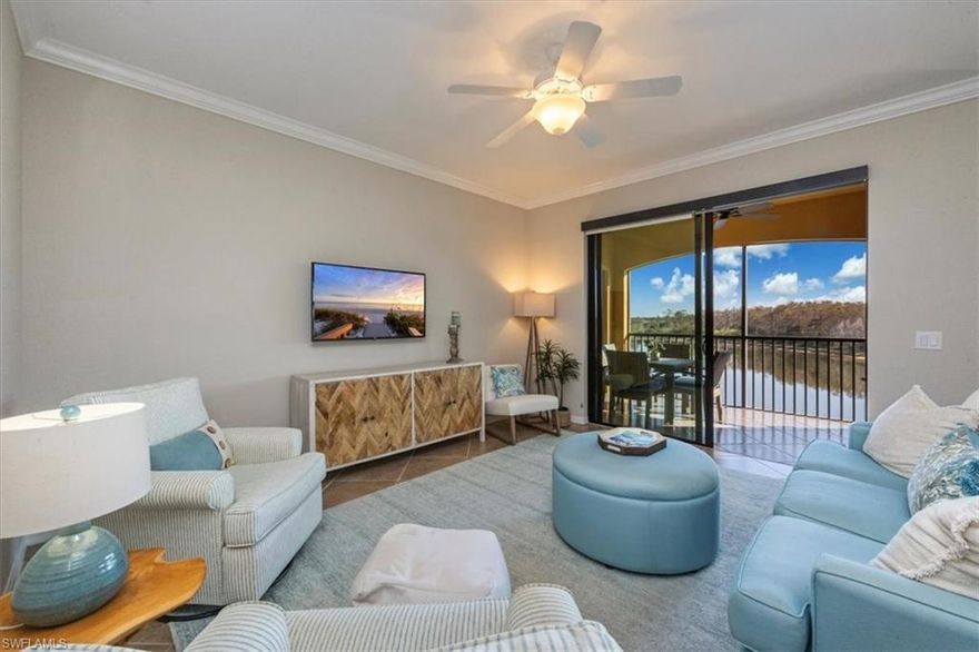 Perched on the top floor, this beautifully updated residence captures breathtaking long lake views and offers a light-filled, open floor plan designed for both comfort and style. The kitchen has been refreshed with white cabinetry, sleek quartz countertops, stainless steel appliances, and a charming breakfast nook that looks out over the water, while the adjacent formal dining room provides flexibility to serve as a home office or den. The kitchen and living area flow seamlessly to the private, screen-enclosed lanai, creating the perfect setting to relax and enjoy the tranquil views. The primary suite features two spacious closets and a tiled walk-in shower, while the guest bedroom and bathroom are thoughtfully positioned on the opposite side of the home to ensure privacy for all. Impact windows and sliders provide peace of mind, and recent updates include a new air conditioning system and washer installed in 2023, a bead-board accent wall in the entry hallway, custom window treatments, plantation shutters, upgraded plumbing valves, custom lighting fixtures, a freshly painted interior, a new smart thermostat, and added tile flooring and a new fan on the lanai. The exterior of the building is scheduled to be painted in an attractive new color scheme, with no assessment , adding even more appeal. This residence has been lovingly maintained by the original owner and includes a deeded covered carport and an extra-large private storage unit.  Located within the prestigious, guard-gated community of Treviso Bay, residents enjoy an exceptional resort-style lifestyle featuring a stunning clubhouse with dining and social spaces, a resort pool with poolside service, a state-of-the-art fitness center, full-service spa, tennis courts, pickleball and bocce, and an active calendar of social events. All of this is set just minutes from downtown Naples, world-class dining and shopping, and the white sand beaches of the Gulf, making this an ideal opportunity to experience the very best of Naples living.