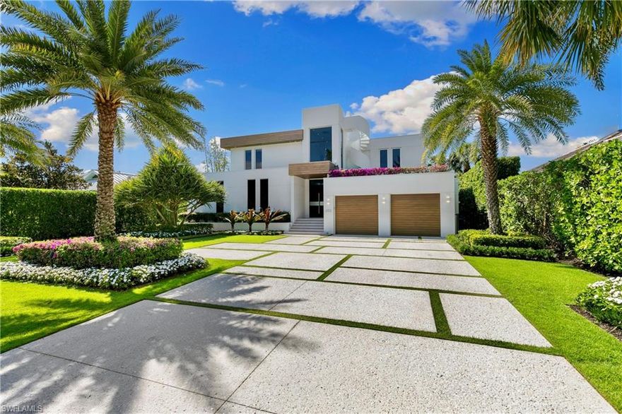 A striking custom contemporary residence ideally positioned in one of downtown Naples’ most sought-after neighborhoods, just a short stroll to the beach and the new Four Seasons Naples Beach Resort. Set on an expansive and private 0.30-acre west facing homesite and built 3 feet above FEMA’s current level with no water close to property or a garage level during any hurricane. This exceptional pool home offers the rare combination of architectural presence, refined interiors, fine craftsmanship with extraordinary attention to details, luxury finishes in a premier coastal location in the very heart of Naples. Built in 2013 and designer renovated in 2023, the home offers 3,843 SF under air and 7,576 total, featured in "Florida Design" and “Gulf Shore Life” design magazines, the home welcomes you through an inviting double door entrance and foyer with 22ft soaring ceilings. Thoughtfully designed for both elegant entertaining and everyday living, the main level features a private study with custom built-in cabinetry, a spacious primary suite with a spa-inspired bathroom including a soaking tub, separate shower, a generous walk-in closet, and a conveniently located laundry room. Sliding glass doors lead to an open sitting area overlooking the private garden and 50 foot double infinity edge pool. The light-filled great room is the centerpiece of the home, showcasing dramatic 18ft ceiling height, a linear double-sided fireplace and a stunning a floor to ceiling wall of glass that frames views of the private oversized backyard, pool and decks. Adjacent is the dining area and a chef’s gourmet kitchen, oversized island with quartz countertops, and imported custom cabinetry, all with picturesque pool and garden views. Sliding glass doors open to a covered lanai designed for year-round enjoyment, complete with a linear fireplace, brand new outdoor kitchen and grill, electric screened enclosure with surrounding lounge decks and pool that creates a serene and private outdoor retreat. The second level presents two generously sized en-suite guest bedrooms, a second-floor laundry, and access, via a sculptural feature spiral staircase, to an open rooftop deck—an extraordinary vantage point to entertain and enjoy sweeping city and sneek Gulf views and exceptional sunsets. Additional highlights include a two-car garage, a custom grass paver driveway and beautiful landscaping. Ideally located just minutes from Fifth Avenue South’s renowned fine dining, boutique shopping, galleries, and cultural venues. Never previously offered to the market, this represents an opportunity to own this exceptional designer residence.