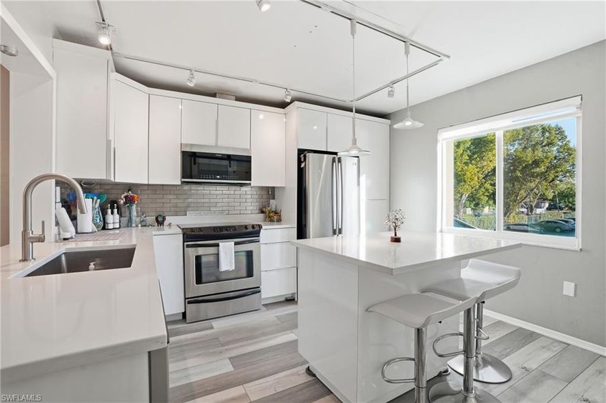 Stop scrolling—this is the one you’ve been waiting for. This exceptional second-story end unit is a rare find and quite possibly the finest residence in the community. Offering over 1,200 square feet, this beautifully updated two-bedroom, two-bath condo blends mid-century flair with modern sophistication. The showstopping kitchen features sleek flat-front gloss cabinetry, quartz countertops, an eat-in island, under-cabinet lighting, a generous pantry with a sliding barn door, and newer appliances—perfect for entertaining or everyday living. Both bedrooms are spacious retreats with private ensuite bathrooms, each showcasing its own distinctive design touches. Impact windows installed in 2022 provide added peace of mind, while the private balcony offers serene landscaped views and enhanced privacy as an end unit. Sold furnished and move-in ready, this home is ideally located just minutes from Downtown Fort Myers, where dining, nightlife, and historic charm await. A rare opportunity like this doesn’t come around often—don’t let it get away.