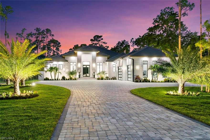 STUNNING NEW CONSTRUCTION...this luxurious home is a dream come true! No detail was spared in the design and construction of this home and focuses on both interior and exterior living to maximize the sunny Naples, Florida lifestyle! Sitting on an expansive, fully fenced 2.27-acre lot, this new construction home was completed in 2024. This home was built for entertaining! Step into this home and be amazed at the soaring 13-foot ceilings and wall of windows flooding the home with light. Elegantly modern, wood detail on the ceilings gives this home warmth and visual interest, and the living room has a dramatic black wooden feature wall highlighted by a 96" electric fireplace with quartzite mantel. The open kitchen features a 13.8' island with waterfall quartzite countertops, Thermador appliances including a gas stove, separate full-sized refrigerator and full-sized freezer, custom cabinetry, pendant lighting, and a breakfast nook with large windows overlooking the pool. The dining area has a stunning linear chandelier and adjoins the wine room with glass doors, custom cabinetry and tile walls. The primary suite in its own wing is a private retreat, with soaring ceilings, glass doors leading out to the lanai, 2 custom walk-in closets, and a primary bath with oversized walk-in shower with multiple shower heads and sprays, freestanding Juliet tub and a floor-to-ceiling Vita Bella polished porcelain accent wall and Mariana chandelier. 3 additional large ensuite bed/baths all feature walk-in showers and custom vanities with quartzite countertops. The 5th bedroom is currently being used as a media room with an 80" wall-mounted TV and Sonos surround-sound speakers and a wet bar with refrigerator. Full bath with wall to ceiling accent tile surround the tub, has custom cabinetry, and a door leading out to the lanai/pool area. Additional powder room with gold accents and custom vanity with quartzite countertops for convenience. The laundry room features 2 LG ultra large capacity washers and 2 LG electric dryers, sink, and storage cabinetry. Additional den/office at the front of the home has glass French doors and wall mounted 65" Samsung TV. Enjoy your outdoor oasis of a lanai of 1,811 sq. ft. covered area and 2,046 sq. ft. uncovered area featuring an in-ground pool and spa, firepit, complete outdoor kitchen, seating area with gas fireplace and wall mounted tv, and multiple seating areas. Truewood Cream wood plank porcelain tile throughout. Eco windows and doors, spray foam insulation, 1,000 gal buried propane tank with Generac full-home generator, electric hurricane shutters, and concrete tile roof, and alarm system with 9 perimeter 4k cameras for peace of mind. Additional 1,664 sq. ft. 2-story, 2-car garage/workshop with 100-amp electrical service on the property.