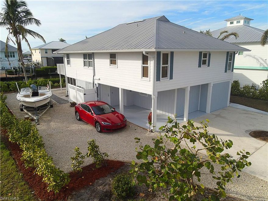 This is the only true waterfront property currently available in this price range on Pine Island, offering a rare opportunity to own in the highly sought-after boating community of Captain’s Cove.

Perfectly positioned on the widest canal in Bokeelia, this home provides immediate, no-bridge access just one minute to Jug Creek and out to Pine Island Sound, Charlotte Harbor, Boca Grande Pass, and the Gulf of Mexico. For serious boaters, the location simply doesn’t get better.

This elevated stilt home welcomes you with an open, light-filled floor plan designed to maximize water views and natural light. The upper-level features three spacious bedrooms with den and two full bathrooms, along with a seamless living, kitchen, and dining area that opens to a large rear deck overlooking the channel. It is the perfect setting for sunset cocktails, morning coffee, and year-round waterfront relaxation.

The kitchen has been thoughtfully updated with brand-new appliances installed in 2025, including a dishwasher, stove, microwave, and refrigerator, providing modern convenience and peace of mind for the next owner.

The fully functional lower level offers exceptional flexibility. With its own private entrance, full kitchen, living area, spacious bedroom, and full bath, it is ideal for guests, extended family, college students, a home office, or potential rental income. This level also includes a laundry room, enclosed patio, fully enclosed workshop with sliding barn doors, and abundant storage space.

The property is designed for the waterfront lifestyle. A private dock features a 10,000-pound boat lift protected by a steel-framed canopy installed by Coastline Boat Lift Covers. Blue dock lighting enhances the evening ambiance, and a KayaArm system makes launching kayaks effortless. The grounds easily accommodate vehicles, an RV, boat trailer, and recreational equipment. An extra-long 80-foot by 20-foot limestone driveway with professional underlayment provides durable, weed-resistant parking, bordered by extensive landscaping and privacy-enhancing clusia plantings.

Over $100,000 in recent improvements have further elevated the property, including more than 60 clusia privacy plants, a navel orange tree, hibiscus landscaping, a fully screened back porch, enclosed carport conversion to a large storage space with possible living potential, granite rock pathways with custom edging, decorative exterior shutters, a charming lighthouse mailbox, remodeled upstairs bathroom, and a newer upstairs A/C system with updated ductwork.

This home combines immediate Gulf access, rare canal width, flexible living space, significant upgrades, and true boating convenience — all within one of Pine Island’s most desirable communities.

This is more than a home. It is a fully realized waterfront lifestyle.