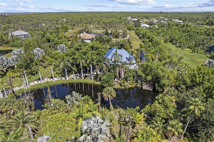 Don't Miss This Rare Opportunity to Own a Piece of Paradise in this Beautiful Old Florida Style Stilt Home Located on 2.5 Acres with a Large Pond with fish & turtles, a small dock & lush landscaping in a private tropical setting. Brand new saltwater pool and front deck! You enter into a large living room with vaulted ceiling & a dining area with french doors to the spacious screened back porch. The kitchen features lovely white cabinetry with some glass fronts, granite countertops & stainless steel appliances. The master bedroom is on the main floor with french doors to the front porch, an ensuite bathroom with dual sinks, a large tiled shower, a walk-in closet, washer & dryer & a door to the screened back porch. There is also a convenient half bath on the main floor. The top floor features an open loft / office area with 2 additional bedrooms & a bath. The lower level has a fantastic efficiency with a private entrance with a covered porch & a fenced section of the yard, a living & dining area, kitchenette, and bathroom. This would be perfect for adult children, a tenant or an Airbnb. Call today to make this your tropical oasis in paradise!