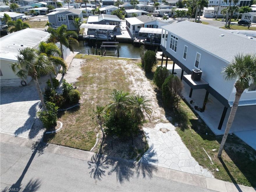 Bayside Estates has essentially two halves’, split down the middle by Stevens Blvd. There is the retention pond side and the saltwater side. Both have their benefits. This lot is located on the saltwater side so there is free and unobstructed access to your aquatic adventures.  Not having to use the boat lift that separates the two sides makes access Hurricane Bay, Hell Peckney Bay, the Gulf of Mexico and beyond is completely about as uncomplicated as it gets. Go shopping and pick out the manufactured home of your liking and have it delivered to this lovely lot and begin partaking in the benefits of this highly desirable community. When looking to buy a vacant lot in Bayside Estates, you might consider a lot that has a seawall that is in good condition like this one.  This lot has a free-standing boat lift, so all you would have to do is bridge the gap between the seawall and boat lift with a dock and you are ready to go.  New homes are being delivered weekly in Bayside Estates and vacant lot are beginning to leave the market to savvy buyers.  Get in before it's too late, come and walk this lot today.  

Bayside Estates is the best kept secret of Fort Myers Beach. This incredibly active and friendly 55+ community is the crown jewel on the gulf coast. Bayside estates is only 2.5 miles to the beach and is accessible by either car or boat--right from either your driveway or private boat dock. A very popular activity is riding your electric bicycles to the beach for the day and visit the world-famous Jimmy Buffett’s Margaritaville. Just don't step on a pop-top!!. Nearly all of the major retail vendors are within a very short driving distance for ultimate convenience. For those who don’t know a lot about Bayside Estates, it is a very fun place to call home---some would even say it’s a mature person’s playground. Whether you want to play pickleball, tennis or bocce ball or hang out at the community pool, or simply cruise the hood in your golf cart, there is always something going on around here. People are friendly and you will be warmly welcomed.