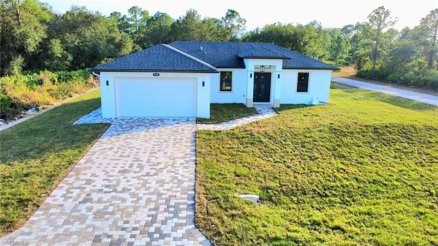Beautiful new construction home located on a desirable corner lot in Lehigh Acres, conveniently near LaBelle and the Homestead area of Lehigh. This 3-bedroom, 2-bath residence offers 1,384 sq ft under air with a 2-car garage and a modern open layout enhanced by high vaulted (volume) ceilings, creating a bright and spacious feel throughout.

The home features impact-resistant windows and doors and losa tile flooring throughout the entire home, including the garage, lanai, and front porch, providing a sleek, cohesive, and low-maintenance finish. The kitchen offers a functional L-shaped design with double entry access and flows seamlessly into the main living area—perfect for both everyday living and entertaining.

The primary bathroom is thoughtfully designed with a walk-in shower featuring multiple shower heads, elegant finishes, and a modern LED mirror and dual sinks. The primary bedroom includes custom closet cabinetry, with additional built-in closet cabinets in one of the secondary bedrooms, offering excellent storage solutions.

Additional highlights include a paved driveway with pavers, automatic irrigation system, tiled garage, open lanai, washer and dryer, and all appliances included. With its corner lot location, quality upgrades, and proximity to LaBelle, SR-80, and major connecting roads, this brand-new home offers modern comfort, durability, and convenience in a rapidly growing area of Lehigh Acres with no HOA.