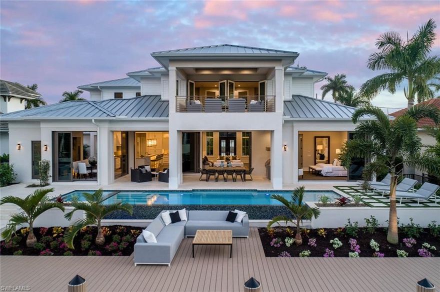 Aqualane’s newest custom designed retreat is now complete, near historic Third Street South and the beach. An expert team of artisans have assembled to create a one of a kind design by architect A. Michael Johnson, and built by Gulfstream Homes. Kira Krumm of Koastal Design Group has detailed a serene combination of earthy hues and natural textures on crisp white backgrounds that create a cool coastal ambiance with a modern flare.  Timeless interior millwork, details, and doors are defined by their clean geometric lines. The wide plank oak flooring brings warmth to this brilliant interior, showcasing custom Ruffino Cabinetry and built ins. Wolf and Subzero in kitchen are doubled in the full size caterers kitchen. Four ovens, wine storage, and ice maker at wet bar. Control 4 automation LED lighting, and Sonos audio are installed.  A luxurious beach house retreat. Architectural Land Design allowed equally impressive outdoor living spaces, with shell stone wet decks graced by exquisite custom landscaping, and accented by a glass tiled waterfall edge pool as the backdrop to the nearly 1,200 sq ft sun deck with plenty of room for watercraft. Three car garage has room for car lifts.