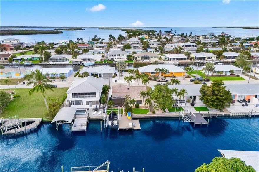 Waterfront Paradise with Direct Gulf Access and SOUTHERN EXPOSURE! Experience the ultimate Florida lifestyle at 2781 Bruce Street.  This beautifully and luxuriously updated home features TWO spacious primary suites, 3-bathroons with a sunroom and offers effortless indoor-outdoor living and PRIME Gulf-access boating with deep water access and one minute out to open waters. Fully renovated kitchen and bathrooms with modern finishes, complimented by plantation shutters throughout, combining elegance and functionality. Wake up to serene canal views, enjoy morning coffee in the sunroom flooded with natural light, and step outside to your private dock with boat lift —and an open, airy layout with large windows frames the sparkling canal and enhances the bright, welcoming interior. This home is being sold fully furnished, making it move-in ready and perfect for immediate enjoyment. Designed for those who crave both relaxation and adventure, it’s ideal for entertaining, unwinding by the water, or launching your boat directly to the Gulf in minutes. Located in a tranquil residential setting in the magical island of Matlacha and filled with olde Florida charm, stunning sunsets, with some of the best fishing right off your back yard!  Stroll over to the many shops/artist galleries just a few streets away, or enjoy the  close to local amenities, this property is perfect for boating enthusiasts, sunseekers, and anyone dreaming of a true waterfront escape.  This is more than a home — it’s a lifestyle. Your waterfront paradise awaits!