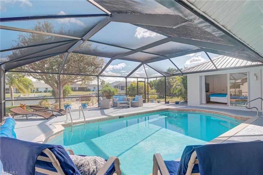 As you arrive, double doors welcome you into a formal living area that sets the tone for this thoughtfully designed 3-bedroom, 2-bath pool home, offering over 2,100 square feet of living space along the scenic San Carlos freshwater canal. The primary suite is located just off the formal living area to the left, creating a private retreat, while the right side of the home features the spacious great room, kitchen, two additional bedrooms, and guest bath—an ideal split-bedroom layout for both everyday living and entertaining. Inside, the bright and inviting interior showcases vaulted cathedral ceilings, tile flooring throughout the main living areas, and abundant natural light. The well-equipped kitchen features a center island with ceramic cooktop, granite countertops with ample prep and serving space, and extensive cabinetry to accommodate all your culinary needs. Pocket sliders throughout the home create a seamless indoor-outdoor connection, offering direct access to the lanai and electric heated pool from the primary bedroom, great room, formal living area, pool bath, and one guest bedroom—perfect for enjoying Florida’s year-round sunshine. The spacious primary suite includes dual sinks, a soaking tub, and a walk-in shower, while all bedrooms feature large walk-in closets. Outdoors, enjoy an oversized lot with mature landscaping and fruit trees including banana, mango, and orange. The freshwater canal and dock provide miles of boating, fishing, kayaking, and tranquil water views. Additional highlights include a new metal roof (2022), new A/C system (2023) and new hot water heater (2025) for added peace of mind. Located just minutes from Veterans Memorial Parkway, downtown Cape Coral, and the Cape Coral Bridge, you’ll enjoy quick access to exceptional dining, shopping, entertainment, and the beaches.