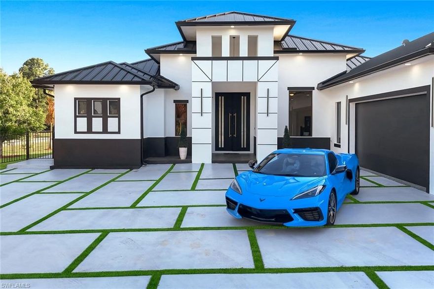 Extraordinary architectural estate situated on 1.25 acres, offering 3,458 sq ft of refined living space and 4,081 sq ft total. Designed for modern luxury with seamless indoor-outdoor living.
A striking arrival begins with a Miami-grass–style driveway and double entrance, complemented by custom oversized modern wood doors, a sleek metal roof, tray ceilings, and black accent features throughout.
The primary suite features custom European-style cabinetry, a boho-inspired quartz vanity and statement shower, LED lighting, dual sinks, and spacious walk-in closets. All bedrooms offer en-suite bathrooms and walk-in closets, providing comfort and privacy throughout.
Interior highlights include porcelain tile flooring, a curated coffee bar, and a chef’s kitchen with top-of-the-line Samsung stainless-steel appliances.
Outdoor living is elevated with a paved saltwater pool (7-ft depth), a fully equipped outdoor kitchen with granite countertops and refrigerator, and expansive grounds ideal for entertaining or relaxation.
Additional features include a whole-home generator, stucco-finished soffits, full-perimeter gutters, a three-car garage, and dual laundry areas with epoxy flooring.
Located in Lehigh Acres, this rare offering combines architectural elegance, acreage living, and modern luxury.