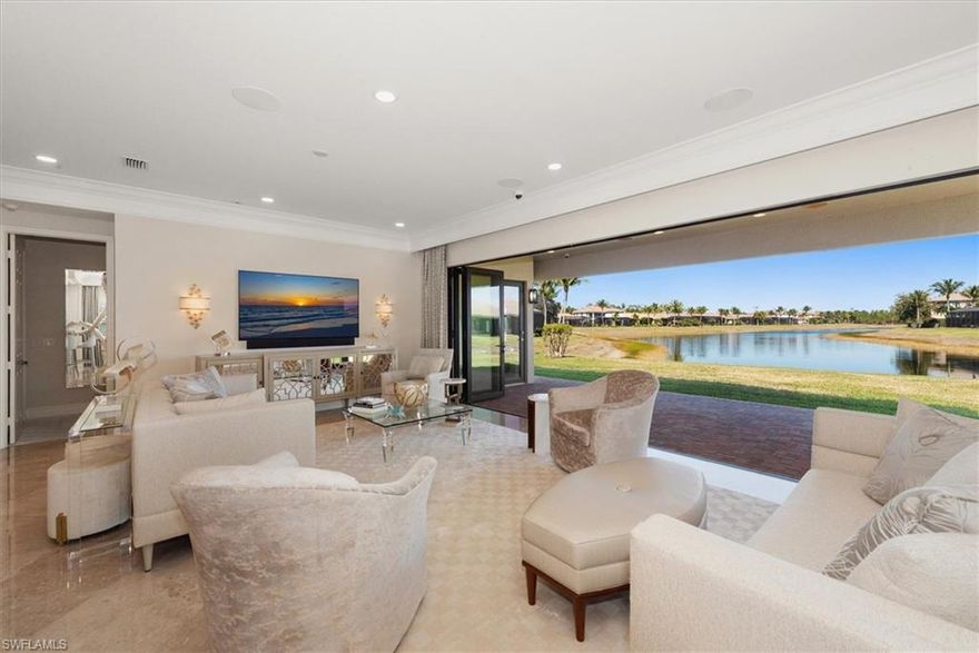 A truly one-of-a-kind offering in Riverstone, thoughtfully reimagined in collaboration with the builder to create a more expansive, light-filled living experience. Set on a premium .27-acre pie-shaped cul-de-sac lot with long, unobstructed lake views, this residence captures a sense of openness and scale rarely found within the community. From the moment you arrive, an oversized Cantera metal & glass entry door makes a striking impression. Inside, attention is drawn through the home to the shimmering lake beyond—an intentional design moment that defines the entire living experience. The foyer sets the tone with marble & tile inlay flooring, echoed above by a coffered ceiling enriched with detailed millwork & beams. The great room has been expertly expanded to enhance both volume & livability, culminating in a dramatic wall-to-wall opening with NanaWall doors that seamlessly connect the indoors to the outdoors—perfectly suited for embracing Naples’ indoor-outdoor lifestyle. The generous lot offers ample space to design a custom pool & spa, with additional room to the side for a fully realized outdoor kitchen & entertaining area. The open gourmet kitchen blends function & refinement with custom white cabinetry extending to the ceiling, paneled refrigeration & dishwasher, a custom hood, ambient lighting, Taj Mahal granite & mother-of-pearl backsplash. A suite of high-end appliances including Sub-Zero, Viking & Thermador completes this exceptional culinary space. A highly functional private study features extensive built-in cabinetry & desk space. Throughout the home, elegant lighting, plantation shutters, custom closets & refined drapery treatments contribute to an elevated aesthetic. The primary suite is a serene retreat, positioned to capture peaceful lake views with direct access to the outdoor living area. The en-suite bath reflects a timeless design with marble counters, custom cabinetry, framed mirrors & designer lighting. Guest bedrooms are thoughtfully tucked away in a split floor plan, offering comfort & privacy, with equally well-appointed baths. Additional enhancements include impact windows & doors, electric shutter, a newer premium Trane HVAC system, a Control4 whole-home audio/video system & surround sound throughout. The laundry room features cabinetry to the ceiling, tile backsplash, utility sink & integrated hamper storage. The garage has been upgraded with epoxy flooring, insulated doors, mini-split A/C, Encore storage cabinets & utility sink. Riverstone offers a vibrant, vacation-inspired lifestyle for all ages. The community features a fitness center, social hall, resort-style pool, lap pool, spa, five lighted tennis courts, outdoor basketball and pickleball, a full indoor basketball court, tot lot, children’s water play area, game room, and an activities coordinator. Within a community known for its vibrant lifestyle & exceptional amenities, this residence stands apart—refined, customized & intentionally designed.