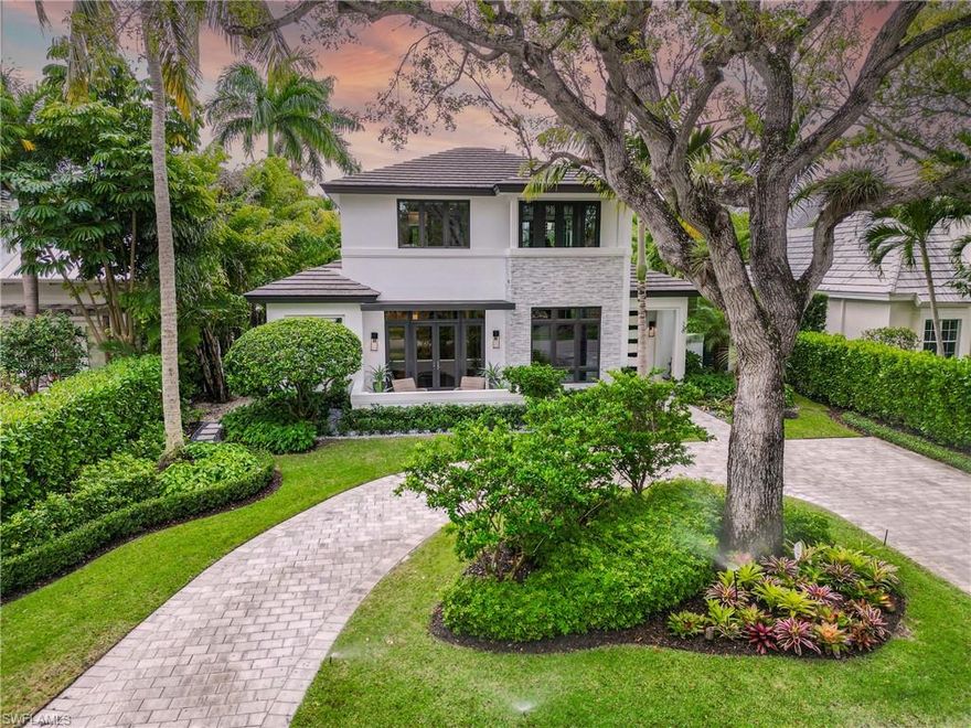 Discover the allure of Olde Naples in this 4 bedroom+clubroom+loft, three-vehicle, two-story, residence, a narrative of timeless elegance unfolding in every corner. Nestled on a mahogany tree-canopied street, just three blocks from the beckoning beach, this home bathes in southern exposure. The exterior, adorned with rock gardens, new low voltage and pendant lighting, sets the stage for a detailed interior.  A harmonious blend of new furnishings, freshly painted interior, captivating pendant and chandelier lighting, state-of-the-art televisions, and home automation.  The culinary has been redesigned with waterfall quartz counters, beverage center and upgraded appliances. Carefully crafted trim ceilings frame each space with architectural finesse. Wide oak plank flooring leads to the main-level primary suite, featuring a sleekly designed primary bath and a step into a private atrium. Upgraded cabinetry in all three guest-suite bathrooms and loft built-ins add refinement in this immaculately appointed home.  Just a walk, bike, or golf-cart ride away, discover shopping, dining, and local parks, seamlessly combining tranquility with access to lively amenities.