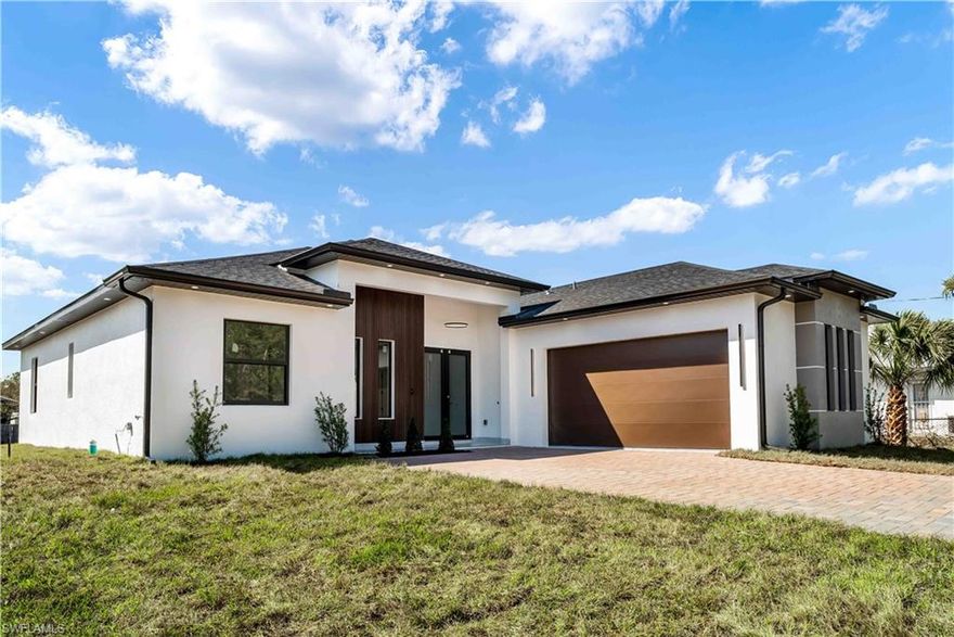 If you are looking for the best value and highest-quality new construction in Lehigh Acres, this property stands in a league of its own. Step into the pinnacle of modern living with this exceptional 4-bedroom, 3-bath residence, thoughtfully designed to deliver both luxury and functionality across 1,866 sq. ft. of refined living space (2,605 sq. ft. total). From the moment you arrive, the home commands attention with its grand 13'4” entry, coffered ceilings, and 10-foot walls, creating an immediate sense of elegance and openness. Expansive 8-foot impact-rated windows and doors flood the home with natural light while providing superior safety and energy efficiency. At the heart of the home lies a chef-inspired gourmet kitchen, showcasing premium stainless-steel appliances, sleek modern cabinetry, and a striking quartz waterfall island with a pop-up outlet—perfect for entertaining or everyday living. Elegant 40x40 porcelain tile flooring throughout enhances the contemporary aesthetic while ensuring durability and easy maintenance. This home is smart-ready, pre-wired for security with a smart doorbell and Wi-Fi-enabled garage, offering convenience and peace of mind. The luxurious primary suite is a true private retreat, featuring his-and-hers custom walk-in closets and an oversized spa-style bathroom designed for ultimate relaxation. Every additional bedroom includes custom-built closets, with one bedroom offering a private ensuite, ideal for guests or multigenerational living. Outside, enjoy Florida living at its finest with a fully equipped outdoor kitchen and an efficient sprinkler system, completing this secure, stylish, and move-in-ready masterpiece. This is your opportunity to own a true forever home. Schedule your private showing today—homes of this caliber do not last. This is more than a purchase; it’s a lifestyle upgrade.