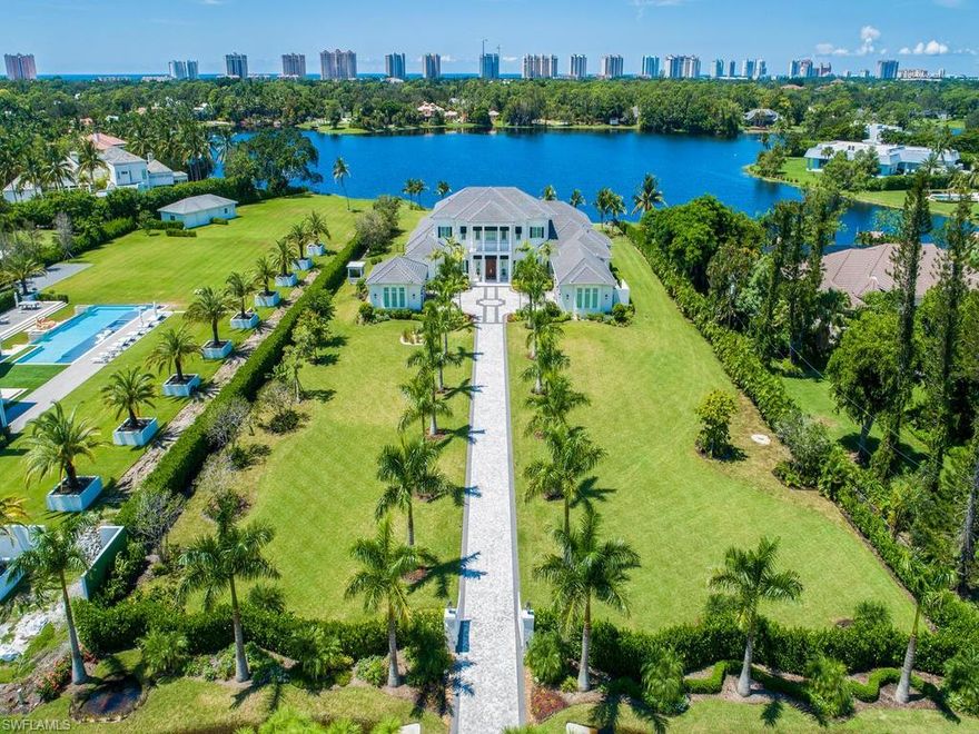 H.13609 - Elegant architectural masterpiece that redefines luxury and sets a new standard of excellence within Pine Ridge. Sprawling across 2.68 acres and ideally sited with approx 200 ft of lake frontage with big lake views. Built in 2016 by Covelli Development, this 9,200 Sq ft residence includes 5-bedroom suites, his/her offices, formal dining, breakfast room & a home theater. This stylishly designed home embodies graceful lines & world-class appointments. Distinguished by 10’ sliders and large windows with transom windows that naturally illuminate expansive interiors. Appointments include wide plank oak & marble floors, exquisite ceiling detail, gourmet kitchen, programmable lighting, Crestron home automation, generator, butler’s pantry & walk-pantry, gas-fireplace, elevator, 5-bay collectors’ garage & much more. The Master quarters comes with his/her dressing rooms, his/her showers & exercise room. The lanai/pool area is enveloped by a tropical paradise with swaying palms & lush landscaping and showcases mosaic tile detailing, gas barbeque & firepit. Close to dining & shopping at Waterside & Mercato and to the Artis. Come see a property that redefines the luxury of Pine Ridge