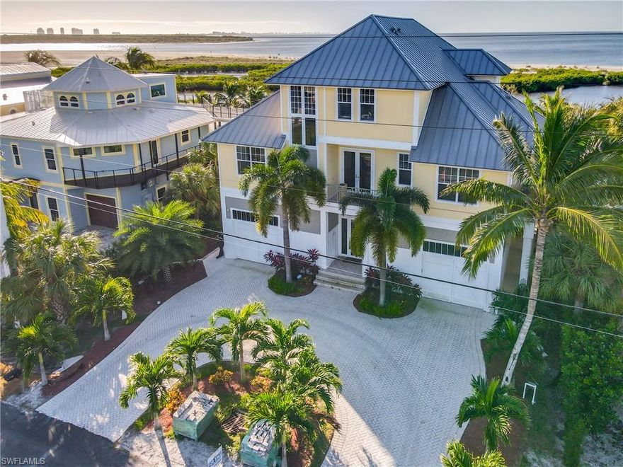 Absolutely gorgeous beach front newer custom home with a heated pool and hot tub. Panoramic views from both large porches. This home features four bedrooms, all with ensuite bathrooms. Custom kitchen appliances, granite tops and cabinets. If your looking for a private retreat, this is the one. The garages are over sized and tall.  Bright and open design with an abundance of sliding glass doors and amazing water views from almost every room. Easy south end location with quick access to Bonita Springs, Naples and Lovers Key state park. This custom built home has plantation shutters, recessed tongue and groove ceilings, crown molding, hardwood flooring, Sonos music system, a heated pool and spa, fenced yard, and a circular paver driveway. Come live the Florida Dream! Own your own piece of paradise.