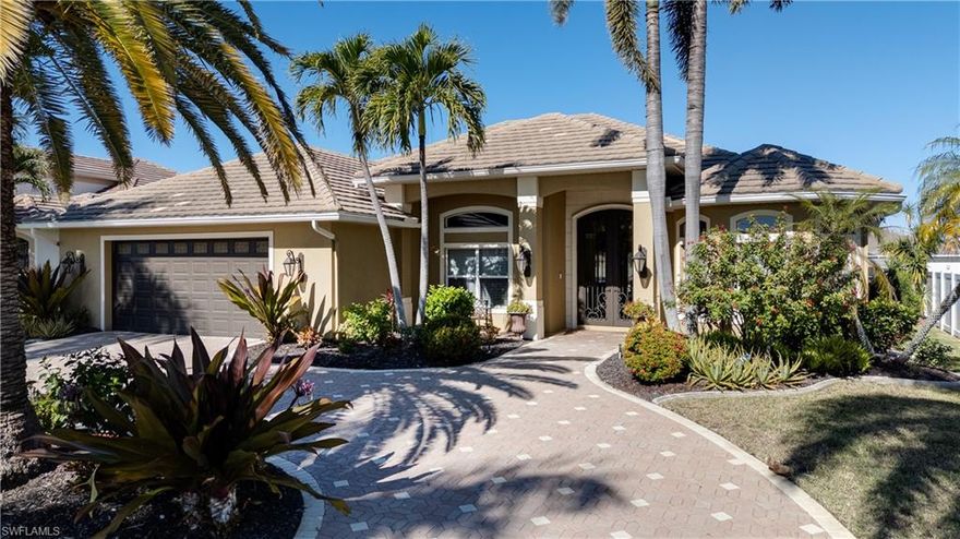 Welcome to LUXURY CUSTOM WATERFRONT living, where refined design meets the ultimate Florida BOATING LIFESTYLE. Ideally positioned just minutes to open water with NO bridges, this residence offers seamless indoor-outdoor living in one of Cape Coral’s most desirable waterfront locations. This tastefully appointed 4 bedroom/ 3 bathroom custom home features thoughtfully designed high-end upgrades throughout. A GRAND 10-foot WROUGHT-IRON ENTRY DOORS opens to soaring double tray volume ceilings with detailed accent lighting and a well-designed split floor plan offering multiple entertaining spaces. Enjoy water views from the primary suite, great room, and media room, all with direct lanai access. The chef’s kitchen is beautifully appointed with custom cabinetry featuring accent lighting above and below, walk in pantry with a second refrigerator, and luxury stainless steel GE Monogram appliances. Interior highlights continue with IMPACT WINDOWS and DOORS throughout, plantation shutters, custom crown molding, built-in cabinetry throughout, listello tile accents, central vacuum, whole-home SONOS SOUND SYSTEM, media room with wet bar and wine refrigerator. Recent upgrades include a new A/C with ultraviolet system and Honeywell smart thermostat. The oversized outdoor living area is truly resort-inspired, featuring a heated SALTWATER POOL and spa with custom LED lighting and a dramatic rock waterfall. Boating enthusiasts will appreciate the 18,000-POUND BOAT LIFT with new canopy and impressive 80-FOOT CAPTAIN"S WALK, offering exceptional dockage and waterfront access. Additional exterior features include composite dock, TIKI HUT, canoe lift/launch, cleaning station, power/water, pool bath, storage room, lush tropical landscaping, upgraded landscape lighting, custom exterior lighting on timer system, new soffits (2022), tile roof, fully FENCED BACKYARD, and an oversized garage with built-in cabinetry. This home had no water intrusion from previous hurricanes. Located within walking distance to Cape Harbour Marina, offering waterfront dining, boutique shopping, live entertainment, and boat fueling, this exceptional home delivers luxury, lifestyle, and location—an extraordinary opportunity for the most discerning waterfront buyer.