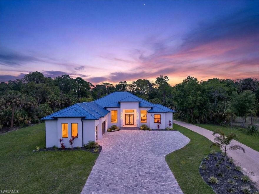 One or more photo(s) has been virtually staged, AI generated or rendered.  Motivated Seller!! This is your opportunity to own  private estate designed for space, freedom, privacy, comfort, and long-term living. Sitting on 2.50 acres of high, dry, cleared upland in Naples, this custom-built residence offers true privacy, thoughtful upgrades, and room to grow. From the moment you arrive, the brick-paved driveway, striking standing seam metal roof, and lush landscaping set the tone. Inside, light-filled open spaces feature oversized 32”x32” porcelain tile, sleek finishes, and a seamless flow ideal for everyday living and entertaining. The chef’s kitchen is the heart of the home, complete with Electrolux appliances, custom cabinetry, and an oversized quartz island, complemented by a whole-house reverse osmosis system. The 5-bedroom, 4-bath layout provides flexibility for guests or multigenerational living, with a spacious primary suite offering dual custom closets and a spa-style bath. Outdoor living is elevated with a resort-style pool with steam wall, full summer kitchen, expansive covered lanai, and tropical landscaping. Built with stem wall construction and premium insulation throughout the main home, garage, and terrace for enhanced efficiency, this property also offers endless potential to expand with guest houses, workshops, or recreational spaces delivering a rare combination of luxury, privacy, and land in Naples.