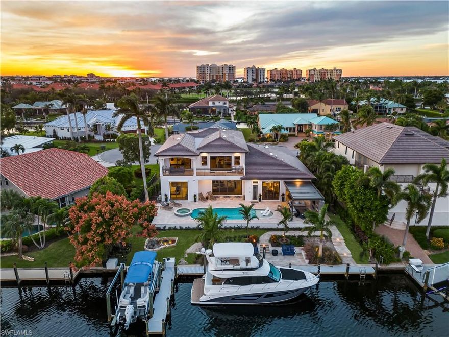 Fully Furnished Reimagined Direct Gulf Access Coastal Contemporary home is a boater's dream with ability to dock a 50+ foot boat and motorized lift to accommodate a smaller boat! 4 en suite bedrooms+office/den, 2 half baths, spacious media room and 3 car garage complete the more than 5600 sq. ft of interior living space. An expansive newly landscaped outdoor oasis creates a seamless indoor-outdoor living connection with waterfront living area, fireplace, custom saltwater pool and spa and second covered living area with outdoor kitchen and dining area. The bespoke interior design is complemented by wide-plank white oak flooring, designer lighting throughout, motorized shades, architectural molding and baseboards, glassed wine wall, chef's quality WOLF/Subzero appliances in the gracious kitchen with large waterfall-edge quartz island, and a second working kitchen and pantry. The open concept is designed for entertaining. The first-floor primary suite offers the owners a perfect retreat with pool access, and thoughtful architectural details. A spa-like en suite bath includes dual vanities, dual-head walk-in shower and soaking tub with floor-to-ceiling tile work. An additional 1st floor bedroom provides a delightful respite for guests with private entry. Upstairs the light-filled landing adds additional flex space. Each of the two additional bedrooms have en suite baths. A sizable bonus/media room has views of the water and access additional covered living area and balcony. The new owner will have peace of mind with hurricane impact windows, and additional motorized shutters, whole house 22kw Generac generator and NEW ROOF in 2023. This property is meticulously maintained and move-in ready offered fully furnished to the discerning buyer desiring the ultimate Florida waterfront lifestyle. Direct access to the Gulf of Mexico is just minutes away via a deep-water canal. A perfect location for the avid fisherman, to daytrip to the beach, or cruise to a delightful waterfront lunch or dinner. Located in one of Fort Myers most prestigious waterfront communities. 3-car garage could accomodate lift, circular driveway.