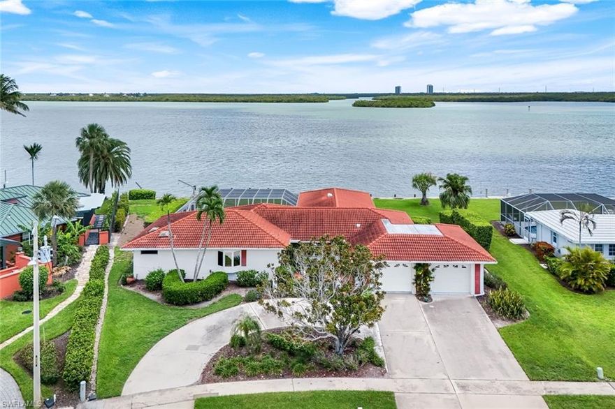 Exceptional waterfront opportunity on the prestigious Marco River, offering over 140 feet of breathtaking frontage with direct, no-bridge access to the Gulf of Mexico. This rare oversized lot invites you to enjoy the current spacious residence or create your ultimate dream estate in one of Marco Island’s most coveted locations. From your lanai, take in the mesmerizing sights of dolphins at play, gentle manatees gliding by, and a vibrant array of coastal wildlife.
There’s ample space to build a custom dock perfectly suited for a large yacht, multiple watercraft, kayaks, and jet skis—ideal for the avid boater. Set off on a quick and scenic cruise to the Gulf for world-class fishing, stop at waterfront dining destinations in Marco Island, Goodland, or Isles of Capri, or venture to a secluded island for a peaceful day on the sand.
The home itself showcases expansive wide-water views from nearly every room. Inside, you’ll find light-filled living spaces with plantation shutters, tile flooring, and a stylish kitchen equipped with a butcher block island. French doors seamlessly connect the interior to the screened lanai, sparkling pool, and spa—perfect for entertaining or relaxing against the stunning river backdrop.
A lush green lawn completes the tropical setting, while the immense potential of this property makes it a one-of-a-kind canvas for luxury coastal living. Envision panoramic water vistas, indoor-outdoor living at its finest, and immediate access to the very best of the Marco Island lifestyle.