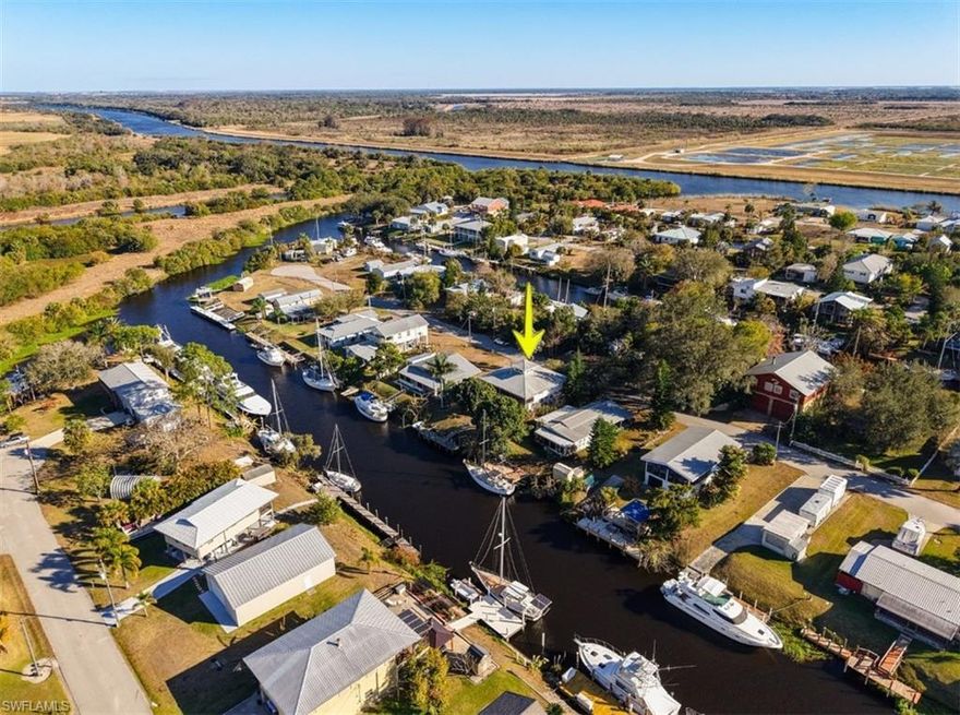 Waterfront Retreat in Turkey Creek – Gateway to Florida’s Legendary Waterways! 

Tucked away in the distinctive boating community of Turkey Creek, an Ortona subdivision adjacent to the historic Ortona Locks, this waterfront home at 1071 Schooner Lane offers an authentic Old Florida lifestyle with exceptional boating access in rural Glades County.

Set on a 65’ x 100’ deep-water canal lot, the property features a sturdy dock equipped with water and electric, providing effortless access to the Caloosahatchee River, part of the Intracoastal Waterway. From here, boaters can cruise west to the Gulf of Mexico or east to the Atlantic Ocean via Lake Okeechobee—making this a rare hub for vessels of all types, from sailboats and trawlers to cruising yachts.

The wood-frame home is elevated on a solid concrete block foundation with concrete pilings and topped with a durable metal galvalume roof. Central air and heat, along with well and septic, support comfortable and efficient living. The upper level offers approximately 1,300+/- square feet, featuring two bedrooms, one bath, a galley kitchen, and a spacious great room for living and dining.

The heart of the home is the dramatic living area, highlighted by a rustic tongue-and-groove vaulted wood ceiling, a cozy Franklin stove, and expansive sliding glass doors that open to a second-living-room-sized screened porch—perfect for relaxing while taking in tranquil canal and waterfront views.

The lower level includes a garage, a workshop with built-in workbench and generous storage for projects, a laundry area, and a second full bath—ideal for boating days and hands-on hobbies.

Ortona is known for its peaceful, nature-rich surroundings, with nearby U.S. Army Corps of Engineers campground and free boat dock, the local Ortona Tavern, and endless opportunities for walking, biking, and birdwatching. Conveniently located just 15 minutes from downtown LaBelle and 20 minutes from downtown Moore Haven, this unique waterfront retreat truly delivers on the promise to slow down, simplify, and savor life on the water.