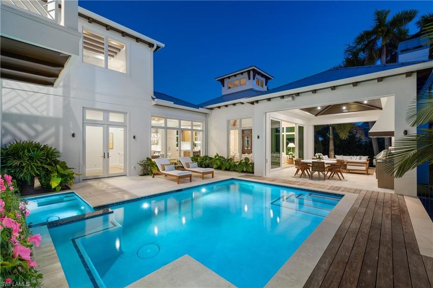 Timeless Coastal Living, Perfected. Just completed and located steps from Third Street South’s premier shopping and dining—and moments to the white-sand Gulf beaches—this new construction masterpiece delivers the ultimate blend of luxury and lifestyle in the heart of Olde Naples. A collaboration by Kukk Architecture, T. Jerulle Construction, Freestyle Interiors, and landscape architect Scott Wyndham, this residence showcases exceptional craftsmanship at every turn. With over 6,700 total square feet, the home features 5 spacious ensuite bedrooms, a dedicated office/den, an elevator, and a 3–6 car garage with lift potential—offering both privacy and effortless livability. Architectural details abound: stained oak beams accent the great room and primary suite, while guest bedrooms feature custom painted beam designs. Wide-plank wood flooring with Francois & Co. herringbone inlays set a warm, sophisticated tone throughout. Designer lighting from Visual Comfort and Palecek adds curated brilliance. The gourmet kitchen is a true showcase, with custom Goguen cabinetry, elegant hardware, a Franke sink paired with a  Waterstone faucet, Cristallo quartzite countertops, and premier Wolf, Sub-Zero, and Fisher & Paykel appliances. The luxurious ambiance continues in the primary bath, highlighted by a Kallista sink and faucet and a serene, spa-inspired atmosphere. A spectacular dining room with high-gloss Ruffino cabinets with backlit Crystallo countertops and Sub-Zero wine storage sets the stage for memorable evenings. A fully outfitted party pantry elevates entertaining, whether hosting intimate gatherings or large celebrations. Designed for seamless indoor-outdoor living, the expansive lanai features a custom fireplace surround, outdoor kitchen, dining space, and generous poolside lounging areas—framing Naples’s tropical charm. The coastal palette of sandy beiges, misty grays, aqua blues, and driftwood browns blends beautifully with the natural surroundings, creating a refined, inviting sanctuary. This is a rare opportunity to own a meticulously curated home in one of Naples’s most coveted locations—where timeless design, masterful craftsmanship, and coastal luxury converge. Welcome home.