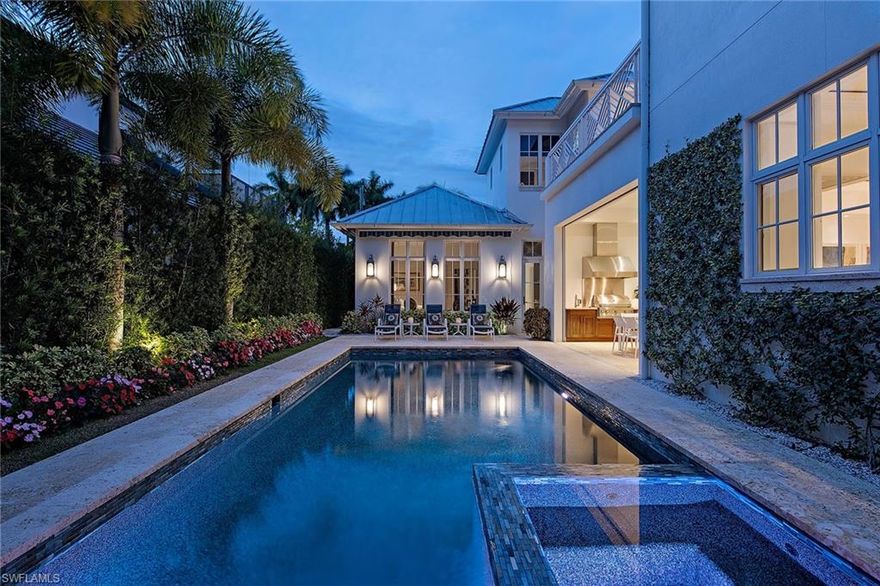 Charming, classic West Indies style Old Naples home. Foyer entry to open and inviting floor plan with large living room featuring high ceilings and Legno Bastone French white oak wide-plank flooring. A gorgeous double marble island kitchen designed for entertaining features Miele appliances, full-size wine refrigeration, gas cooktop, a separate "butler's kitchen” and formal dining room. Spacious first floor master with large bathroom and walk-in closet, study, two powder rooms (including pool bath) plus three second-level en-suite bedrooms with sitting area and balcony. Amazing outdoor space with lush landscaping, pool and spa with retractable awning, two outdoor living spaces and a summer kitchen. Mahogany doors and shutters, electric roll down screens and shutters surround the outdoor living space. Front driveway parking with rear access to an attached 3-car garage. Elan G home automation system. Designed by Falconer Jones. Prime Old Naples location just blocks from shopping and dining at 3rd Street South, Crayton Cove and the beach.