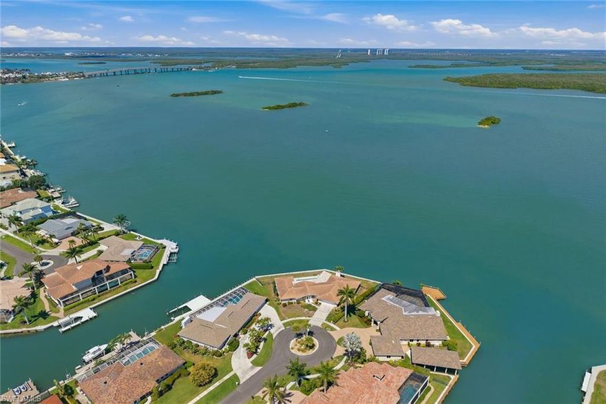 A rare opportunity to secure one of Marco Island’s captivating tip lots, where breathtaking, wide-water views take center stage. Positioned to capture sweeping panoramas of the Big Marco River, Sanctuary Sound, Charity Island and iconic Jolley Bridge, this exceptional homesite delivers an ever-changing backdrop of natural beauty, vibrant wildlife and shimmering evening skyline views. With its unique point location, the property boasts expanded waterfrontage with over 180 feet of waterfront, direct Gulf access and a remarkable sense of openness that is increasingly hard to find. Whether you envision a custom waterfront estate or a refined coastal retreat, this lot provides the ideal canvas to bring your vision to life. The expansive shoreline presents a prime opportunity to design and build a custom dock and boating setup tailored to your lifestyle, maximizing the full potential of this exceptional setting, and without impacting your view. The property features a single-story residence with four bedrooms, 2.5 baths and a two-car garage, ideal for immediate enjoyment, potential rental income or use while planning your future build. The home offers 12-foot living room ceilings, porcelain tile flooring throughout, and a functional layout that flows seamlessly to the outdoor living area with a pool, covered lanai and stunning water views. Recent improvements add value and peace of mind, including a seawall replacement (2015), tile roof (2019), updated plumbing (2019) and newer HVAC systems (2023 and 2024). This is a one-of-a-kind offering where unparalleled views, premier location and limitless potential converge, an extraordinary chance to create a legacy property on Marco Island. Marco Island is an exceptional 24-square-mile island offering the ideal balance of refined resort living and relaxed coastal charm, elegant yet comfortable, vibrant yet never overwhelming. Consistently recognized for its safety and home to some of the beautiful award-winning beaches in the country, the island delivers an unparalleled lifestyle. Residents enjoy effortless access to executive air travel, as well as a short, convenient drive to Naples for expanded dining, shopping and cultural experiences. Locally, everything you need is close at hand, from marinas, yacht clubs and premier golf courses to fitness centers, tennis and pickleball facilities, and favorite pastimes like yoga on the beach, paddleboarding and kayaking. Boutique shopping, museums, and an array of fine and casual waterfront and beachfront dining options create a dynamic yet easygoing atmosphere, complemented by everyday conveniences including grocery stores, salons and pharmacies. Life on Marco Island is simply effortless, where luxury meets livability in one of Southwest Florida’s desirable coastal communities.