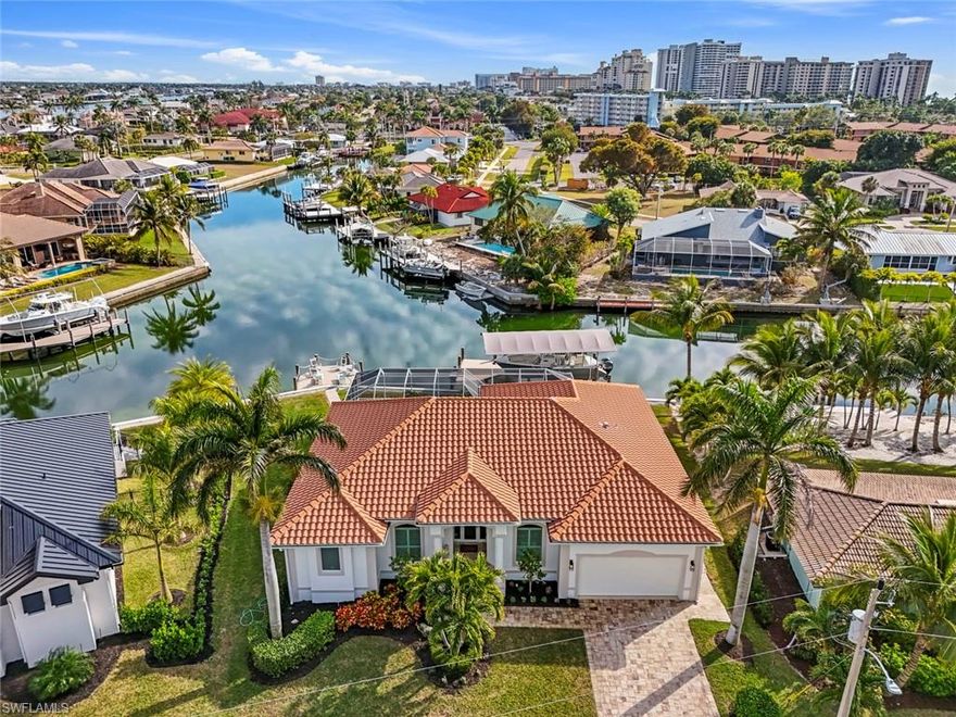 Simply put, this incredible home will wow you the moment you walk in the front doors! Located three blocks to Marco Island's Resident’s Beach! Enjoy spectacular, wide & intersecting water views with breathtaking sunsets from the lanai and large pool & spa. The extensive interior and exterior renovations completed between 2023 and 2024 reflect the highest standards in design and craftsmanship. No expense was spared! New impact glass and doors plus an electric shutter to protect the lanai furniture. Beautifully furnished! With the high ceilings and open floor plan, this house feels much larger than the square footage indicates. The 119’ 2021 seawall with new 2024 dock is complete with a canopy and 20K pound lift. A second lounging deck is perfectly placed to take in the long water views & sunset. One bridge (14.4' vertical clearance) by Esplanade for quick gulf access. The kitchen layout was professionally designed to be functional and elegant. Retreat to the primary suite and enjoy a spacious spa-like bathroom with soaking tub and walk-in shower. Two walk-in closets. Guests will find their own sanctuary with comfortable bedrooms and a stunning pool adjacent updated bathroom and a third beautiful updated full bath. 2024 whole house generator with propane tank! Roof 2017. Walking distance to restaurants, Farmer's Market, Veteran's Park events, Esplanade & shopping, Mackle Park children's park, trails, dog park, & sports programs, pickleball & tennis. Minutes to Resident's Beach-$200/year offers parking, cafe, Chickee Huts, Grills & one of the best beaches in the world!