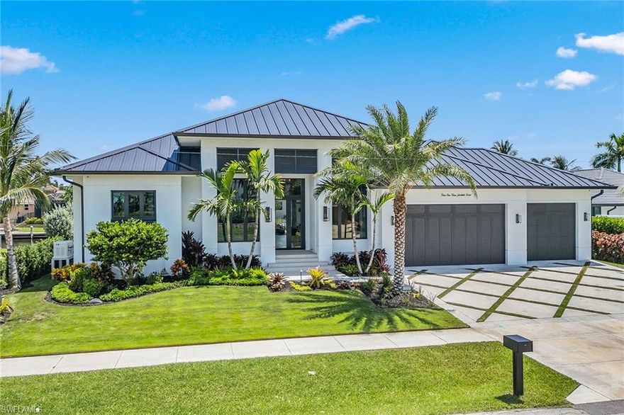Welcome to this unique custom waterfront home, newly built in 2023 on an oversized lot with direct gulf access and tranquil water views! This luxurious boater's paradise offers four bedrooms, 3.5 baths and a spacious three-car garage in 3,045 square feet of exquisite living space. Better than new, this home is being sold turnkey with luxurious high-end furniture and furnishings. Why wait two years for your dream home to be built when this one is ready now? The residence features northeast exposure, a metal roof, impact doors/ windows, and electric shutters. The wide driveway along with an auto sprinkler system and fenced backyard enhance the property's curb appeal. The expansive lanai, with remote-controlled no-see-um screens, offers breathtaking canal views. Boating enthusiasts will appreciate the private new boat dock with a new seawall, 20,000-pound lift and dual jet ski lift, providing direct water access with a short ride to the Marco River. The large covered outdoor living area includes an outdoor kitchen with a built-in alfresco gas grill, mini refrigerator, sink, heated saltwater pool with sundeck, and spa and outdoor shower. The open floor plan features recessed lighting, custom cabinetry, tray and volume ceilings, and hardwood floors. The elegant foyer with a double-door entry, tray ceiling with cove lighting, and chandelier sets a grand tone. The chef's kitchen is complete with white modern cabinets, quartz countertops, under-cabinet lighting, hidden outlets, walk-in pantry, large center island with a breakfast bar, and top-of-the-line appliances including an eight-burner Wolf gas stove, Wolf Sub-Zero refrigerator and freezer, wine refrigerator and Miele coffee system. Adjacent to the kitchen, the formal dining area and living room offer stunning water views, and the lanai sliders fully open for a full view and access to the outside. The living room features a built-in entertainment center, electric fireplace, and a wet bar with custom shelving, wine refrigerator and ice maker. The owner's suite is a serene retreat with lanai access, two walk-in closets, and an en-suite bath with porcelain tile, dual vanities, Halo LED mirrors, quartz countertops, wooden cabinets with under-cabinet lighting, walk-in shower and a separate soaking tub. The versatile guest bedroom can serve as an office with French doors, custom shelving and a walk-in closet. The second guest bedroom has a walk-in closet and en-suite bath, while the third guest bedroom offers the same amenities plus lanai access with a private view. The laundry room/mud room features a utility sink, quartz countertop, storage cabinets, and new Electrolux front-load washer and dryer. This home includes a new whole-house generator, a new underground 1,000-gallon gas tank, and a smart home system with remote access. The deep three-car garage features epoxy flooring and recessed lighting, providing storage and workspace. Don’t miss the opportunity to own this serene waterfront retreat.