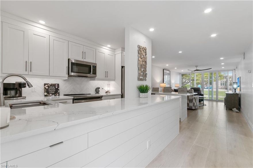 An incredible opportunity to own a fully renovated 2-bedroom, 2-bath condo, completed in 2025!  This highly sought-after floor plan features a light-filled, beautifully designed kitchen with stainless steel appliances, quartz countertops, and a sleek induction range-perfect for modern living.  Enjoy peace of mind with heavy-duty impact sliders, doors, and windows, along with classic plantation shutters throughout.  The home also offers tile flooring for easy maintenance, solid two-panel interior doors, an in-unit washer/dryer hookup, and covered parking!  All state inspection requirements have been met, with reports available upon request.  Ideally located in downtown Naples, you're just a short walk to the beach and the shops and restaurants of Third Street!  Residents of Village Green enjoy a vibrant community with fantastic amenities and activities-making this a perfect place to call home!