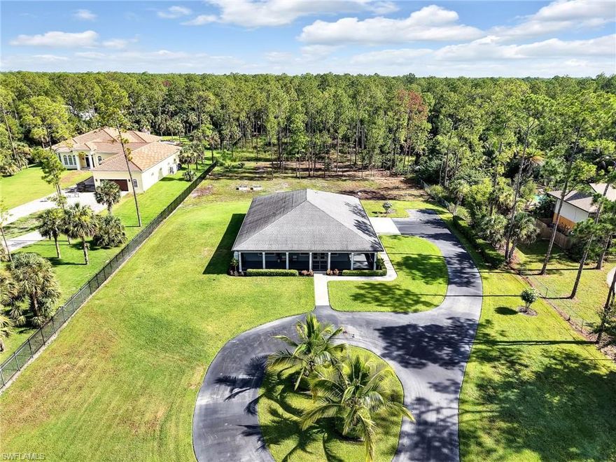 North Naples – Discover a rare opportunity in Collier Woods / Golden Gate Estates: This 2.5-acre property is 100% uplands and thoughtfully designed for comfort, convenience, and long-term livability. The homeowner meticulously planned every detail, with features ideal for ADA accessibility and aging in place, including zero-entry access (even from the garage) and extra-wide doorways for wheelchair navigation.

Peace of mind comes standard with impact glass windows and doors, a whole-house generator, a humidistat in the insulated attic, and a battery back up for the upgraded garage doors. The oversized three-car garage is a hobbyist’s dream—equipped with an exhaust fan and three 240-amp outlets for electric vehicle charging, heavy machinery, automotive work, or woodworking.

Inside, the gourmet kitchen takes center stage with a massive quartz island, Bosch stainless steel appliances, double oven, French door refrigerator/freezer, and a vented microwave. Soft-close wood cabinetry, an under the counter reverse osmosis system, and a water softener enhance everyday living. The open-concept floor plan flows seamlessly, while the additional large interior storage room and zoned A/C systems add functionality.

The outdoor spaces are equally impressive—prepped for a summer kitchen, a raised garden in the backyard, and a beautifully paved circular driveway. The entire front and side porch are screened-in for family enjoyment, the elevated front yard for drainage, and perfect for play. This oversized acreage homesite, provides ample space to add a larger main residence, smaller guest home, large custom pool, or outbuilding at the rear of the property.

Absolute serene setting with plenty of room for expansion make this the perfect choice. 4445 5th Ave SW is located in an A-rated school district and ideally positioned near premier shopping, dining, beaches, and regional airports—all supporting the best of the Florida lifestyle.