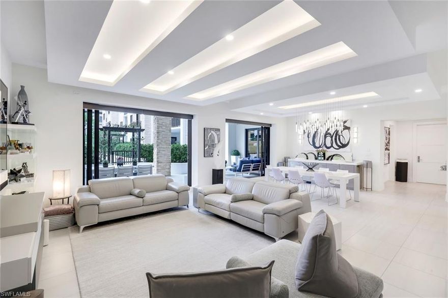 Rarely available southern-exposure, courtyard-level Emerson model featuring an extended lanai providing a total of  3,464 square feet of refined indoor-outdoor living. Thoughtfully designed with no detail overlooked, this residence welcomes you with an elegant foyer that makes a striking first impression, showcasing luxurious tile flooring, custom ceiling treatments, architectural return vents, and designer lighting that flow beautifully throughout the entire residence.

The gourmet kitchen is a chef’s dream, appointed with premium appliances, including a gas cooktop, built-in wall ovens, and a dedicated Miele coffee station. Sleek white cabinetry is beautifully complemented by stunning quartz countertops, while a built-in wet bar with sink and wine refrigerator enhances both everyday living and entertaining.

The same level of craftsmanship extends to the primary suite and two guest bedrooms, each offering a private ensuite bath and walk-in closet. A versatile den with custom frosted glass doors provides the perfect space for a home office or reading retreat.

Additional highlights include two deeded garage parking spaces in the secured garage. Residents enjoy resort-style amenities, including a lush courtyard, pool and spa, fire pits, club room, and state-of-the-art fitness center. Ideally located in Naples’ vibrant Design District, just steps from premier dining, shopping, cultural attractions, and the beautiful white sand of Naples.