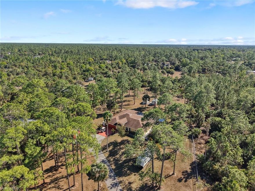 Welcome to a rare opportunity to own a no HOA home on 2.53 acres in Golden Gate Estates, offering space, privacy, and flexibility just minutes from Naples conveniences. Located at 2610 6th Ave NE, Naples, FL 34120, this beautifully maintained single-family residence sits on a cleared, fully fenced lot with a private electric gate, making it ideal for buyers searching for homes with land in Naples, acreage properties, or horses-ok estates with no restrictions.

This 3 bedroom plus den, 2 bath home features soaring 12-foot ceilings and multiple bay windows that flood the interior with natural light, creating a light, bright, and sunny atmosphere year-round. The split bedroom floor plan offers privacy and functionality, while the spacious great room and dining areas make everyday living and entertaining effortless.

Designed with versatility in mind, this is a true multi-generational home with the potential for a separate mother-in-law apartment or additional rental income unit. Whether you need space for extended family, guests, or a work-from-home setup, this property adapts to your lifestyle.

The primary suite is generously sized and includes a huge walk-in closet, dual sinks, and a walk-in shower. Step outside to enjoy a long, extended screened patio, perfect for outdoor entertaining, relaxing evenings, or future pool plans with plenty of room to expand.

Additional highlights include a new whole-house generator, providing peace of mind during electrical outages, as well as multiple storage sheds, ideal for those who work from home, need extra storage, or collect cars and equipment. The home is equipped with well water, septic, storm shutters, and a two-car attached garage, all situated on an oversized lot with room for RVs, boats, and future additions.

If you are searching for a Naples home with acreage, no HOA restrictions, privacy, and income potential, this Golden Gate Estates property delivers exceptional value, freedom, and long-term flexibility in one of Collier County’s most desirable rural communities.