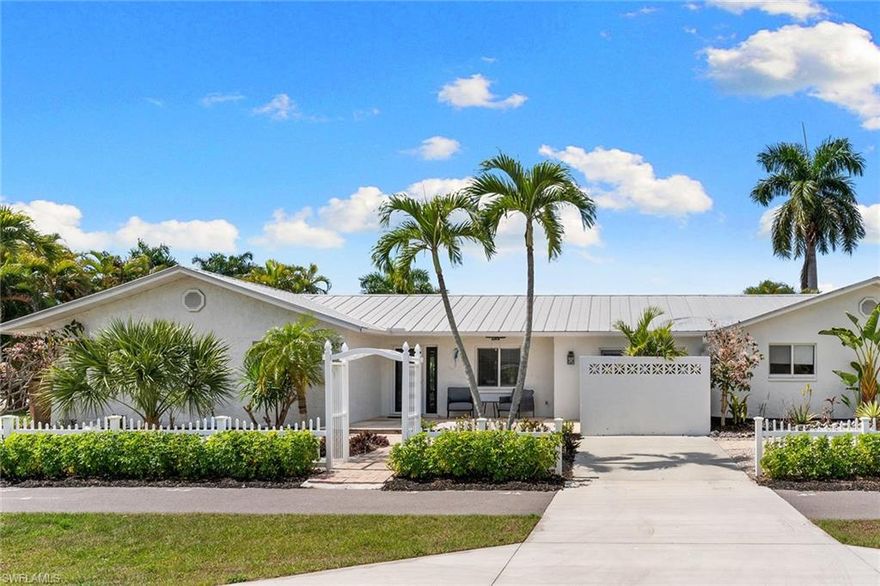 Ideally in the desired neighborhood of Naples Park, this exceptional residence sits on a rare, oversized corner lot surrounded by lush, mature landscaping that creates a private tropical retreat. Ideally west of U.S. 41, the home offers an effortless blend of coastal elegance, comfort, and investment potential just moments from Naples world-class beaches and vibrant lifestyle amenities. Inside, the thoughtfully designed split-bedroom floor plan provides openness and privacy. The beautifully updated kitchen serves as the heart of the home, featuring elegant quartz countertops, a generous center island and sophisticated black stainless appliances, ideal for everyday living and entertaining. A formal dining room offers a refined setting for hosting intimate gatherings and memorable dinners. Go outside to your resort-style oasis. The expansive 25-by-13-foot heated pool with sun deck is surrounded by paver decking and a spacious 42-by-13-foot screened lanai, creating a seamless indoor-outdoor living experience. An outdoor kitchen and grill make entertaining effortless, while the charming poolside cabana with luxury vinyl flooring and its own mini-split air-conditioning system provides a versatile space ideal for guests, a private office or a relaxing lounge. Additional enhancements include impact windows and doors, LED recessed dimmable lighting throughout, remote-controlled ceiling fans, and an integrated surround sound system with six ceiling speakers, receiver and television, all included in the sale. The fully fenced yard offers exceptional privacy, and the oversized garage provides ample room for vehicles, storage, or a workshop. Approximately one mile from the white-sand shores of Vanderbilt Beach and the natural beauty of Delnor-Wiggins Pass State Park, and just minutes from the upscale dining, shopping, and entertainment of Mercato and The Pavilion, this location places the best of Naples at your doorstep. With no HOA, flexible rental potential, and an elevation of 13 feet above sea level with no hurricane damage or flooding, this property presents a rare opportunity to enjoy the ultimate Naples lifestyle, whether as a full-time residence, seasonal escape or exceptional investment.