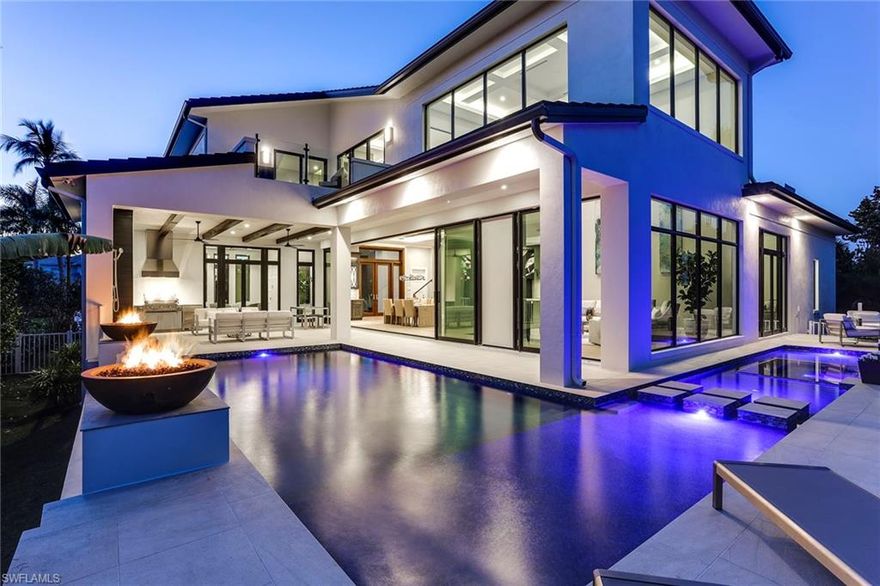 This architectural masterpiece was conceived and constructed by one of the finest teams in luxury home building. Set perfectly on the finest street in Naples with sweeping western views of the Venetian Bay and one-half mile to the beach, this state-of-the-art luxury home will immerse you in rare, exotic beauty in harmony with nature. Beyond the massive Mahogany entry doors, all eyes will be cast upon two-story walls of glass and stunning views of the deep blue wrap-around pool lit by Southern sun. Open flowing rooms are accentuated by warm natural woods and imported stones. A grand gourmet kitchen anchors the home and multiple indoor/outdoor living spaces ensure the ultimate Florida lifestyle. Owners will enjoy an ultra luxe Master Wing that provides a decadent retreat complete with Ensuite spa. Floating staircase or optional elevator will carry guests to another private, second level entertainment area. Offering four bedrooms plus den and an open air deck that capture transcendent views of the resort style pool flanked by lushly grown landscape and views of the western sunset. Artfully designed, this exclusive home offers today’s sophisticated homebuyer luxury beyond compare.