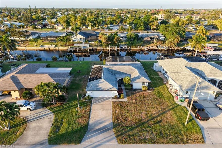 Mid-century modern meets contemporary coastal at this gulf access pool home with 7,000 lb boat lift and dock. 
This home is sold fully furnished and is  an Airbnb Guest favorite with a whopping 4.94 Star Rating and over 66 reviews. Amy from Traverse City MI says: "Our family of four loved this place. It’s bright and colorful, and very spacious and comfortable. We felt both right at home and on vacation at the same time. ?? The pool in the back was fun, and watching boats go by on the canal was also entertaining. We also enjoyed walks in the neighborhoods,  and saw several little burrowing owls hanging out on mailboxes at night!" Cory from Las Vegas, NV says" This was our second time staying in this house located at Cape Coral. Plenty of places near by to eat and shop. The house and pool are always very clean and the area is peaceful and quiet. Amgad is always responsive to any questions, answering within seconds. Will definitely be back for a 3rd stay!" These are just a few of the raving reviews. Jump right into Airbnb hosting or make this your next home. 
The home features a desirable split floorplan which offers privacy for your guest and family. Primary suite includes dual closets with a large updated ensuite primary bath, a tranquil retreat - featuring both a large walk-in shower and deep luxurious soaking tub. This home was truly designed with you in mind. Everything from the colorful joyful colors in the bedrooms to the tranquil modern dinning room. Comfy sofa and multiple lounge areas. Kitchen has stainless steel appliances, wooden cabinetry & granite counter tops. Guest bath was also stylishly renovated within the last 3 years. Rounding out this home is 2 car garage and includes washer and dryer. 
Outdoors, enjoy the expansive screened lanai overlooking the solar-heated pool and serene canal that goes out to the gulf with only one bridge along the way. The City of Cape Coral  with its many canals, parks & great restaurants, is rapidly growing, offering new opportunities and developments, making it a top place to live, work, and visit in Florida.