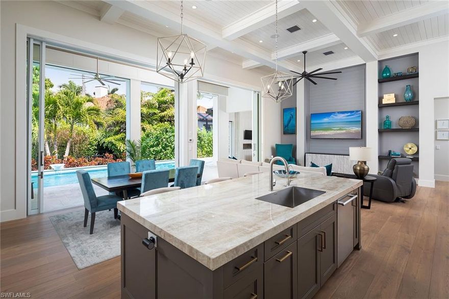 Situated in a spectacular West of Crayton location, this coastal-inspired residence was penned by R L Keith Architects and built by Trademark Development Group. Enjoy beautifully appointed one-level living with Legno Bastone floors and tongue and groove ceilings that soar to nearly fifteen feet. The primary suite, conveniently connected to the laundry room, boasts two expansive custom walk-in closets, a coffee bar, and a separate tub and shower. Additionally, the residence features a pool bath and an additional powder room, catering to both comfort and functionality. The magnificent great room is accentuated by a stunning two-sided gas linear fireplace shared by the conversation room and the adjoining office/study. The Epicurean kitchen offers bespoke cabinetry, a large custom pantry, and Thermador professional series appliances. The oversized lanai boasts automated screens and shutters, opening to the spillover pool and spa, and the outdoor kitchen with a fireplace provides a picturesque setting for gatherings and relaxation. The garage boasts high ceilings and doors, offering ample space to accommodate lifts for the car enthusiast.