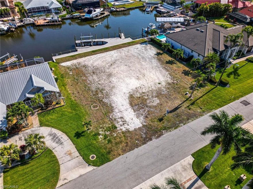 BRAND NEW 10FT PANEL SEAWALL!!  BRAND NEW COMPOSITE DOCK WITH 24,000 LB LIFT!!!  3 LOT SITE!!! SOUTHERN EXPOSURE!!!  WITHOUT A DOUBT THIS IS A PREMIER LOT IN SOUTHWEST CAPE!!!  This exceptional property boasts sailboat access, situated on a three lot site along a wide canal. Conveniently located within walking distance to Cape Harbour.  With it being a large oversized lot, your dream home possibilities are endless,.  Also, Residents can enjoy easy access to their favorite local restaurants, shopping destinations, and vibrant nightlife. Additionally, the property is just five minutes away from the river.  The property features  and incredible 120 feet of brand new 10-foot panel seawall, providing added security and durability. A new boat dock with all composite deck surface.  This lot offers residents the perfect opportunity to enjoy Florida waterfront living at it's finest.  Don't miss out on this unique opportunity to own a prime waterfront property in a sought-after location.